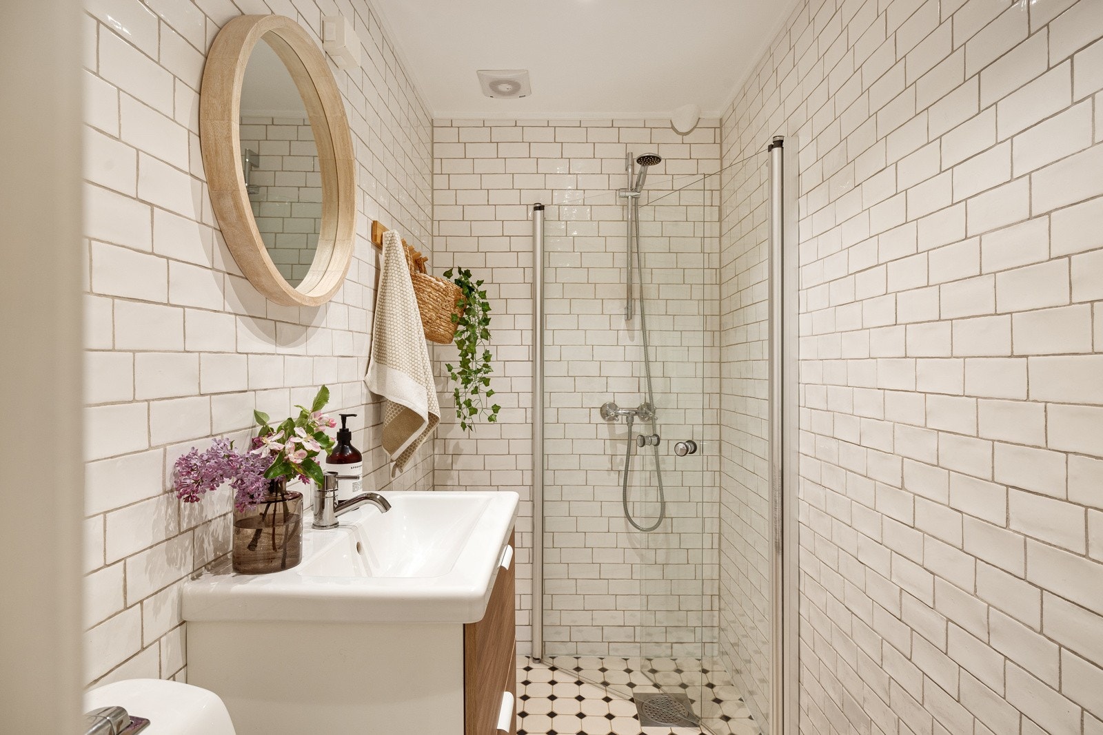 Badet som ligger i 1. etasje er pent og tidløst med dekorative fliser på gulvet. Galleribilde