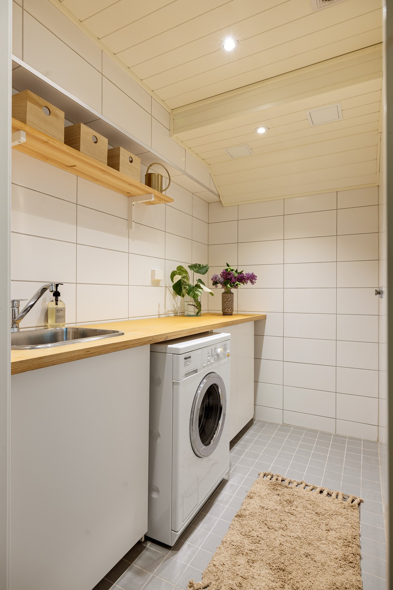 Fra kjellerstuen er det inngang til et veldig praktisk vaskerom fra 2015. Vaskerommet har flislagte overflater og gulv med sluk og varmekabler. Her er det opplegg til vaskemaskin/tørketrommel. Galleribilde