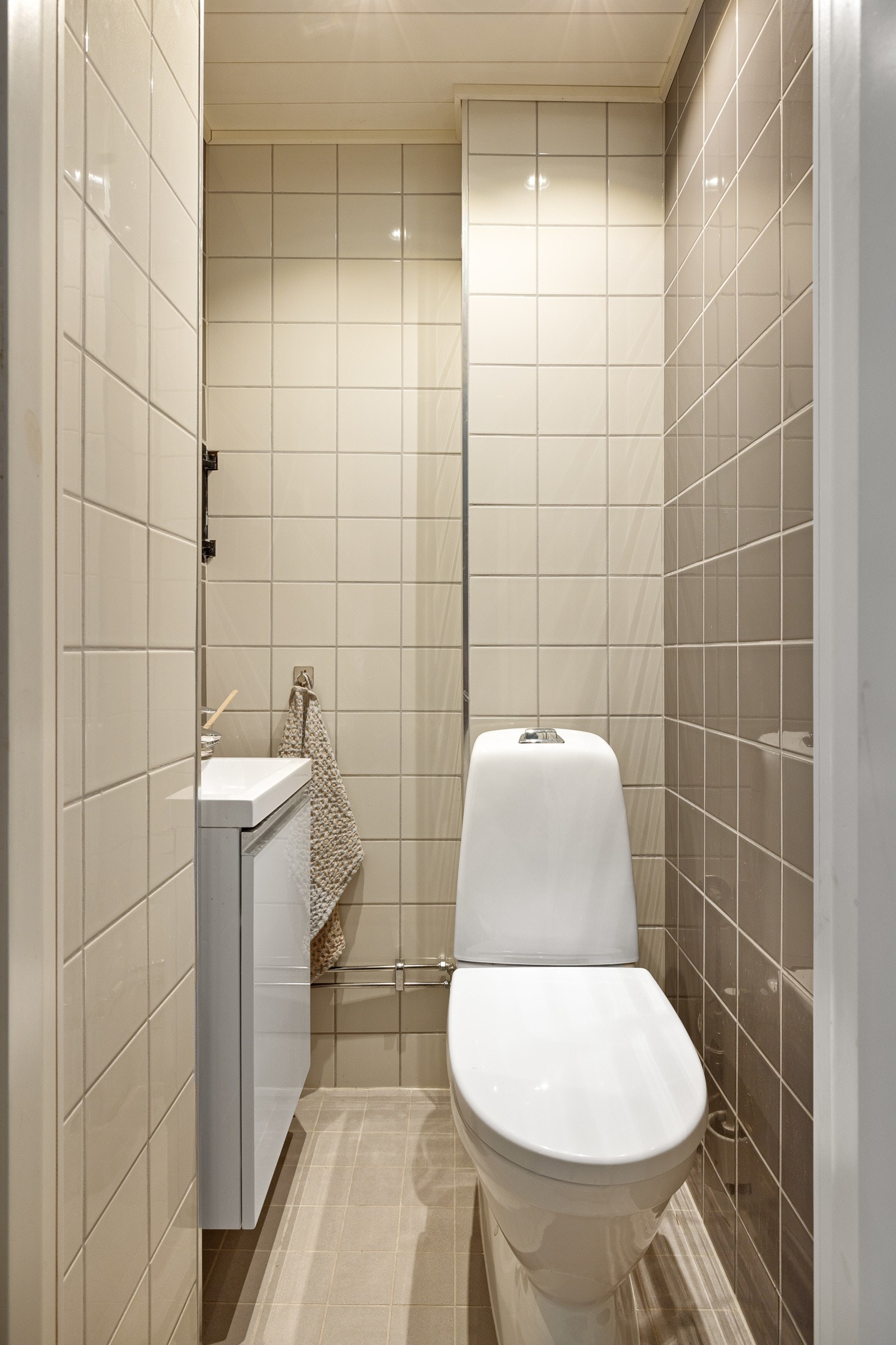 Fra kjellerstuen er det inngang til toalettrommet. Toalettrommet fra 2015 har tidløse fliser med varmekabler i gulvet. toalett, servant med speil og underskap. Galleribilde