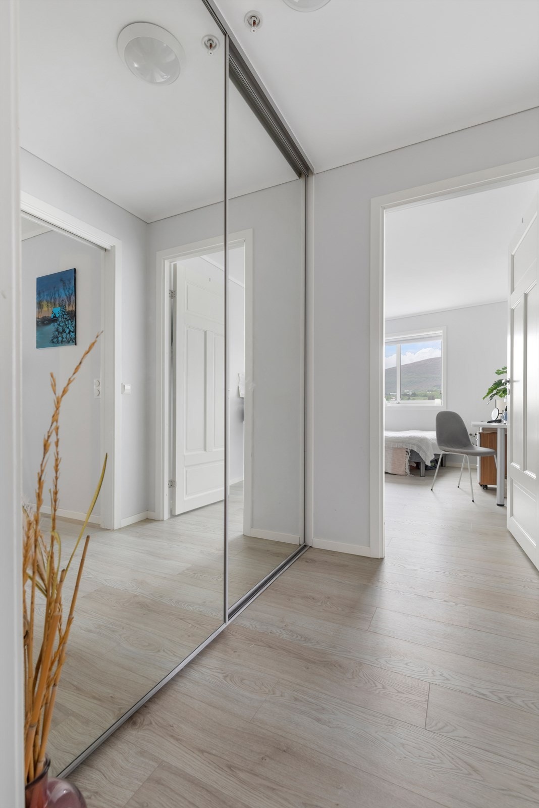 Mellomgang mellom bad og soverom har walk-in-garderobe med speilskyvedører Galleribilde