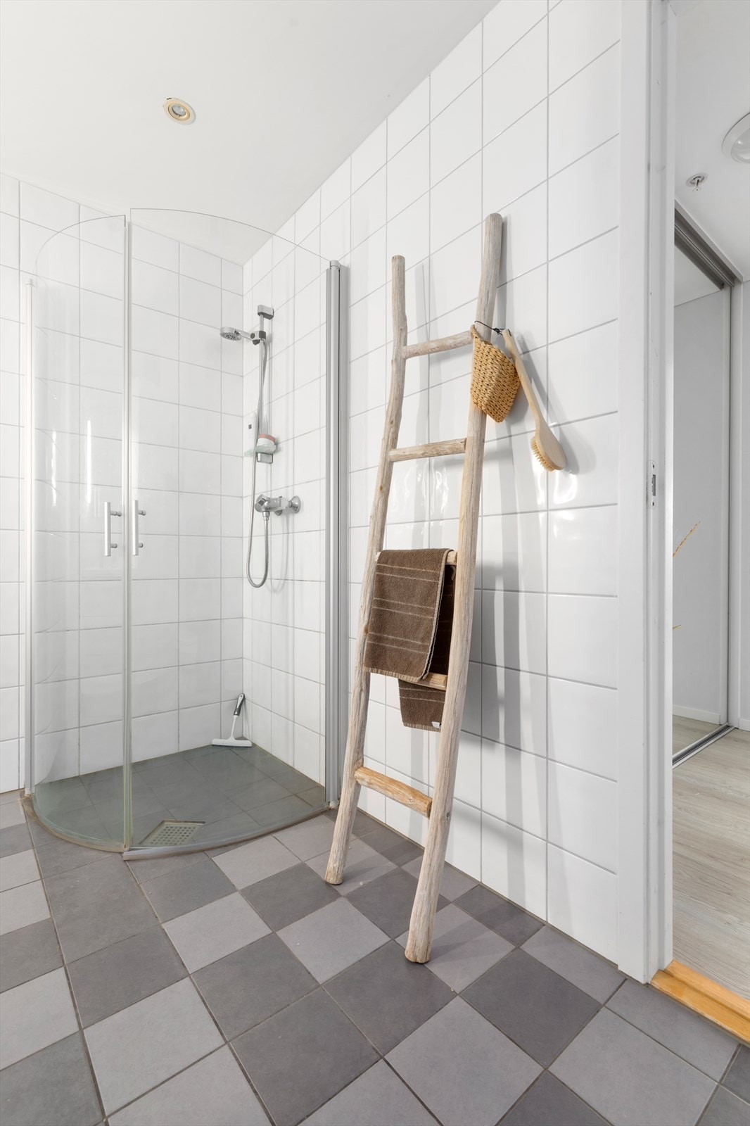 Helfliset hovedbad med vannbåren varme i gulv | badet er utstyrt med vegghengt wc, baderomsinnredning og dusjhjørne med buede glassdører Galleribilde