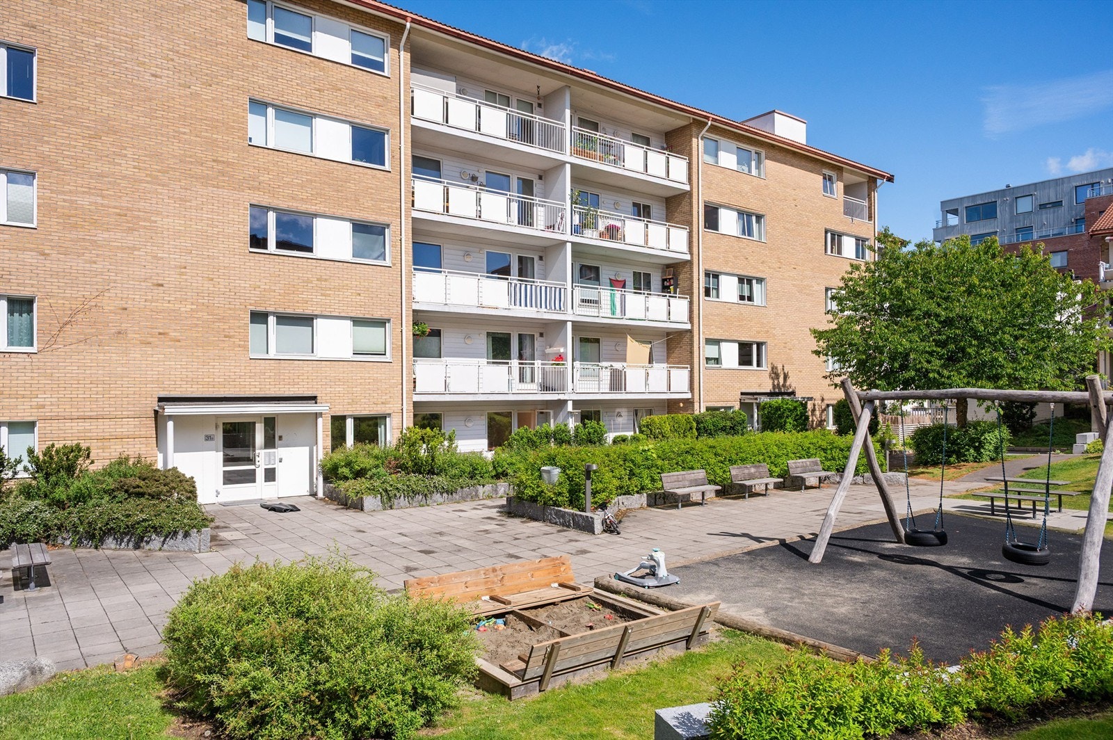 Barnevennlig bakgård med lekeplass og grønne omgivelser - et sosialt samlingspunkt for nabolaget. Galleribilde