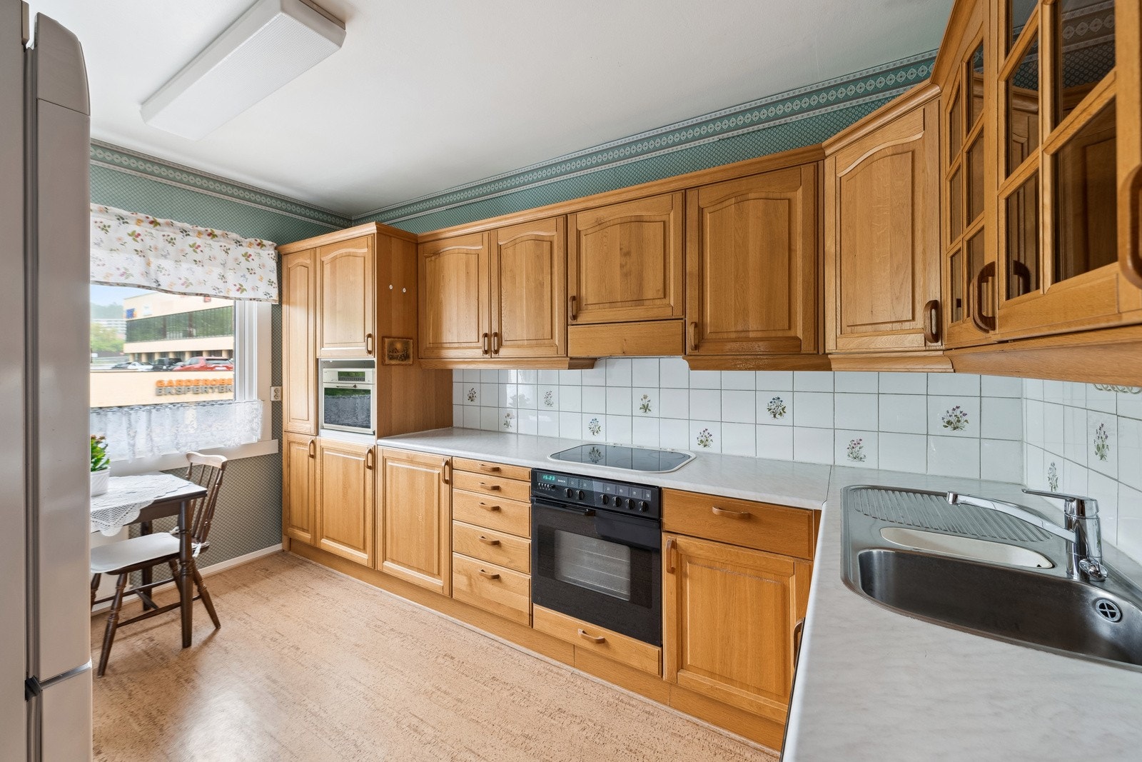 Kjøkkenet er utstyrt med integrert stekeovn, platetopp og oppvaskmaskin, samt et frittstående kjøleskap. Ventilatoren er plassert i overskap. Det er installert automatisk vannstopper med fuktsensor. Varmtvannsbereder er plassert under kjøkkenbenken. Galleribilde