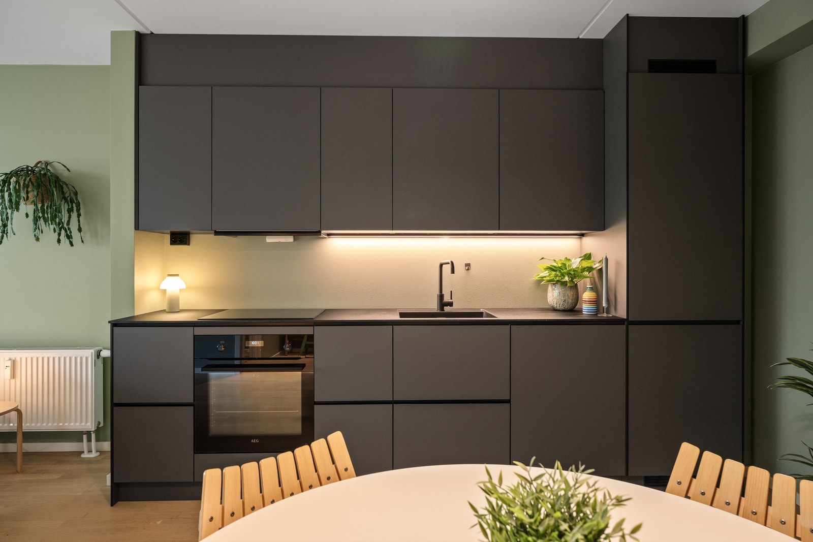 Hvitevarene er sømløst integrert og består av platetopp, stekeovn, oppvaskmaskin og kjøl/fryseskap. Det er montert waterguard og komfyrvakt. Avtrekk over kokeplass. Galleribilde