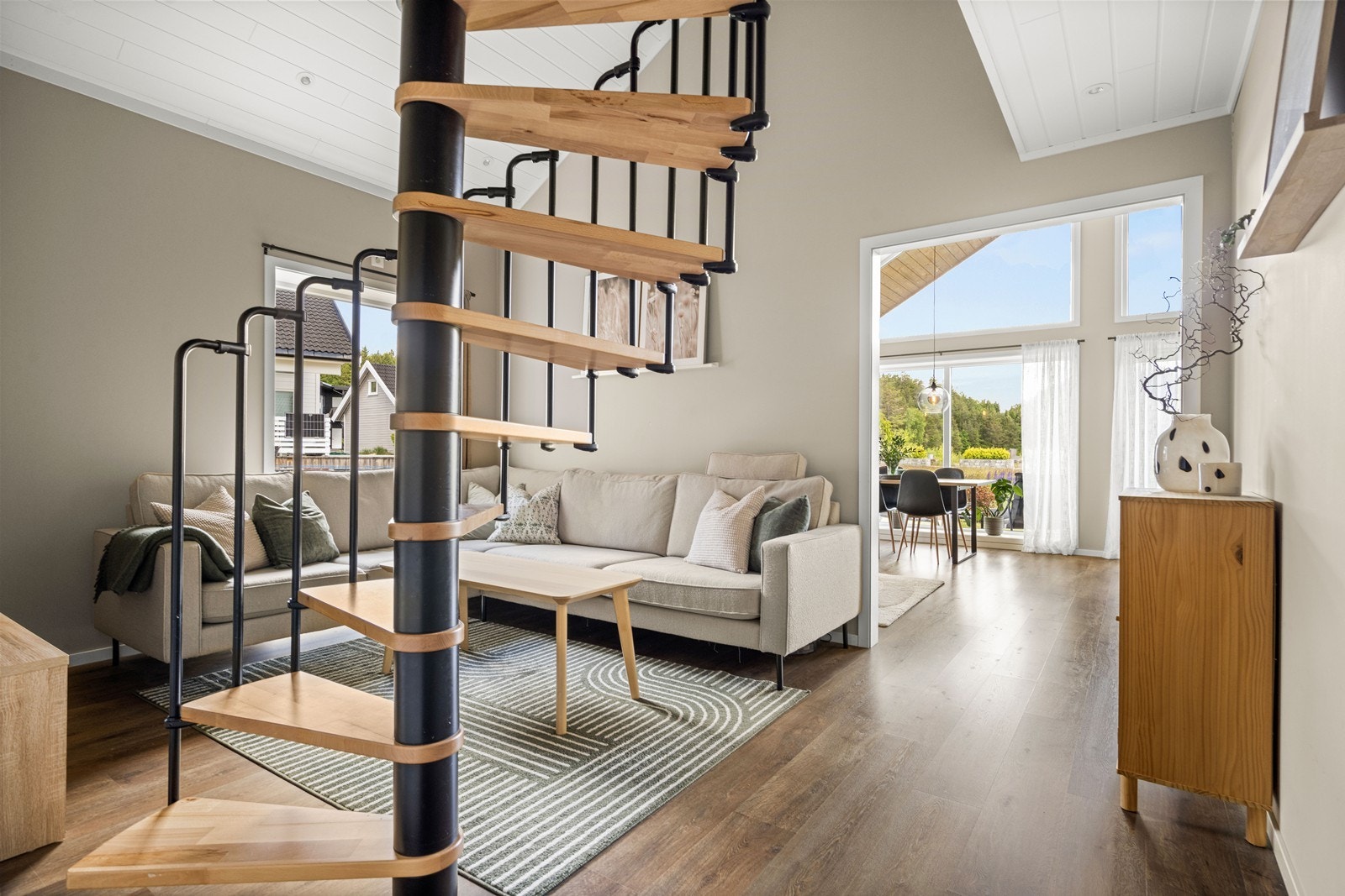 Tv- stue med stilig vindeltrapp opp til bortstuingsloft Galleribilde