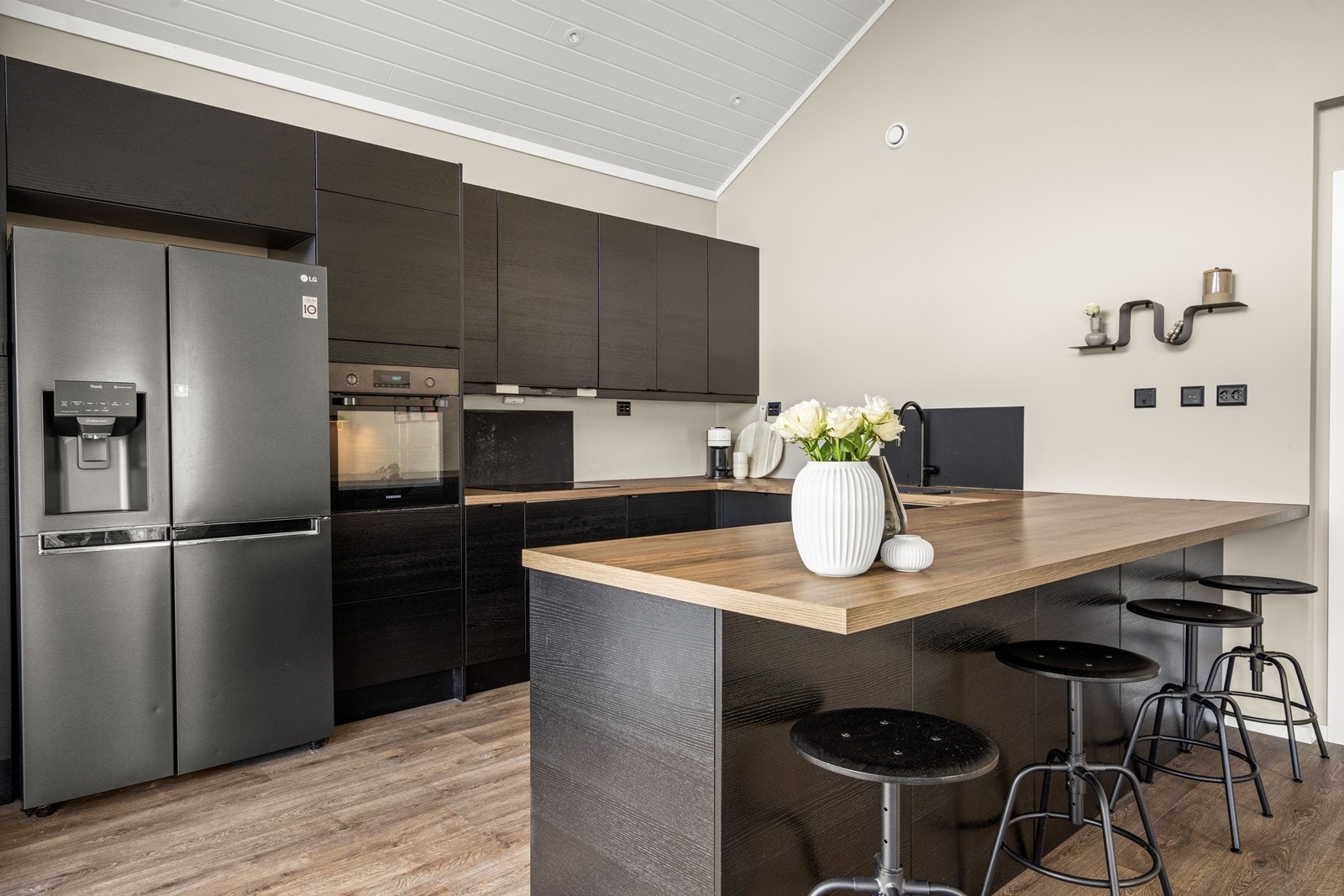 Kjøkkenet er moderne og romslig med integrerte hvitevarer og godt med skap og-benkeplass Galleribilde