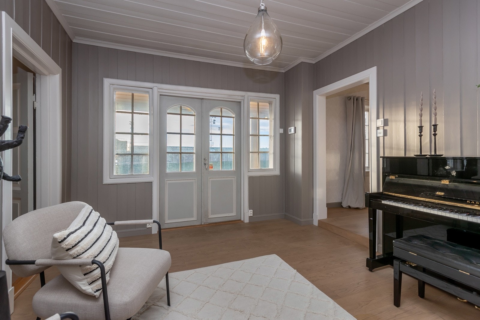 Doble verandadører ut til en liten trappeavsats hvor det er plass til en liten sittegruppe Galleribilde