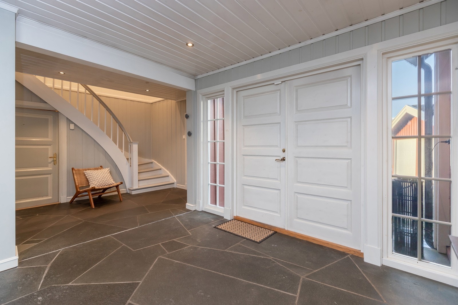 Hallen er omfangsrik og flott. Doble dører og glass på siden slipper inn lyset i rommet. Galleribilde