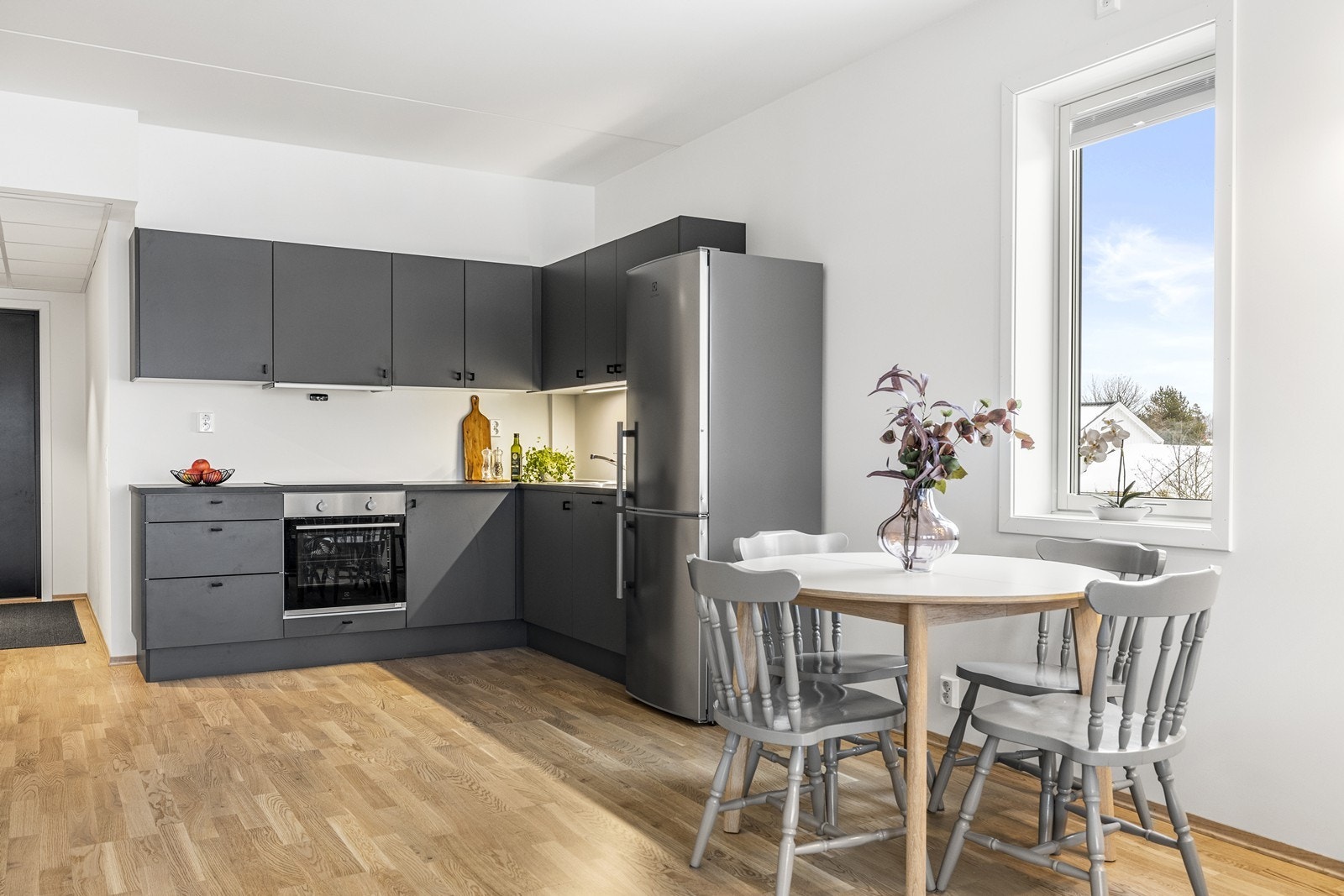 Kjøkkeninnredningen består av skap med glatte grå fronter og benkeplate i laminat. Galleribilde