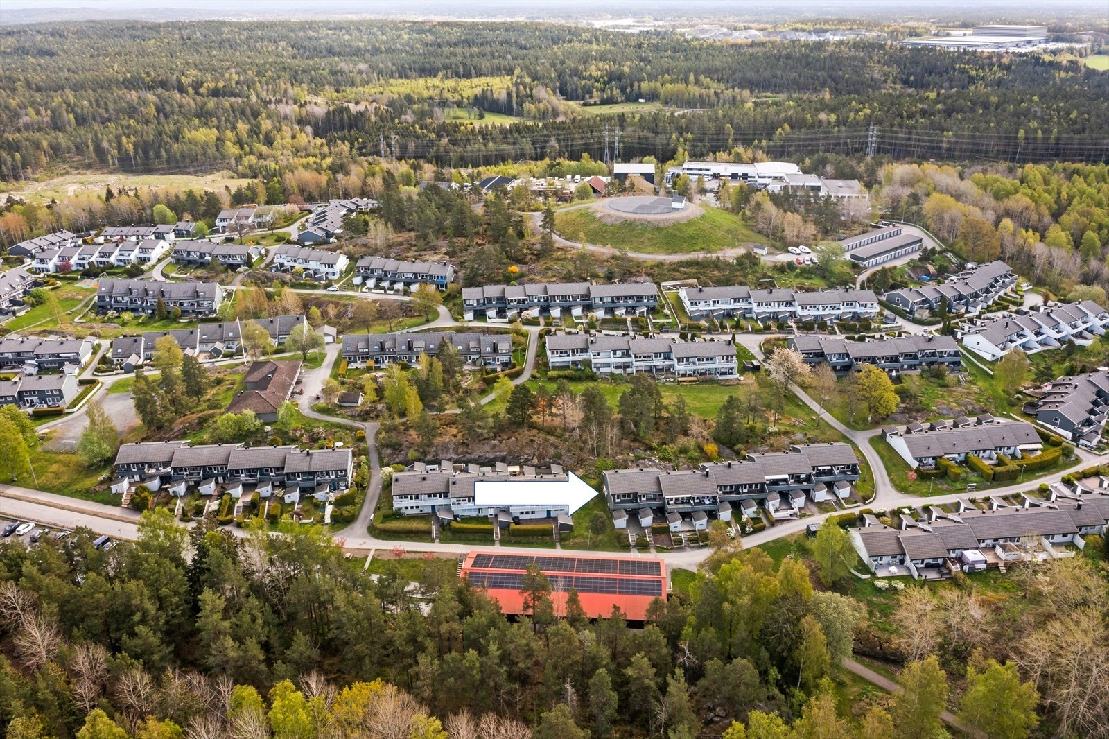 Oversiktsbilde av borettslaget. Garasjeanlegget har solceller på taket. Galleribilde
