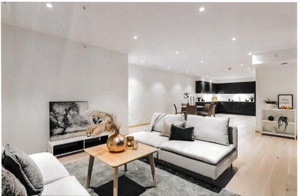 Den åpne stuen fremstår som meget innbydende i lyse, delikate fargevalg. På gulvet er det lagt en nydelig 14 mm hvitpigmentert enstavs parkett som strekker seg sømløst inn i kjøkken og soverom. Galleribilde