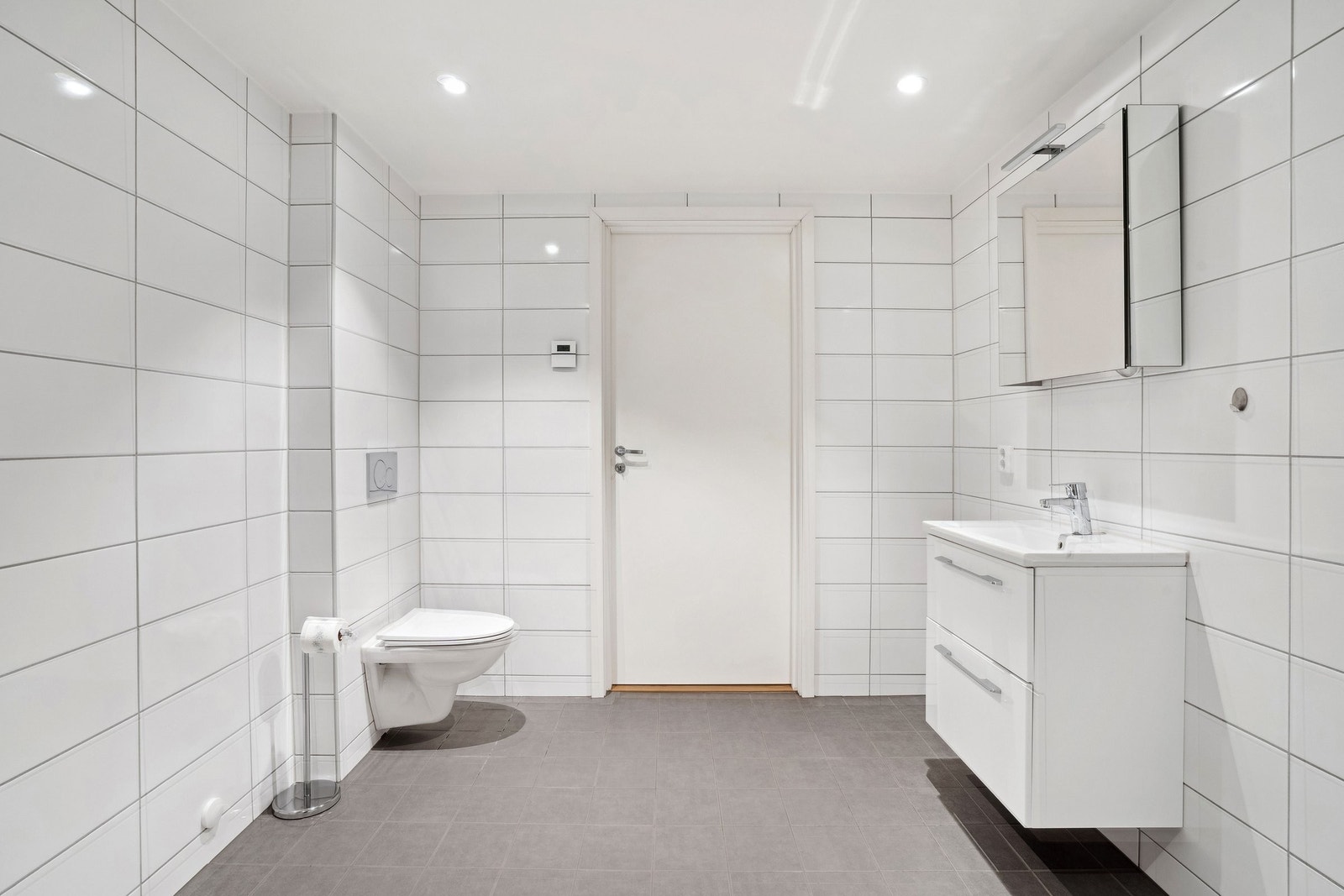 Videre er det vegghengt toalett i lekker hvit porselen med dempersete. Det er avsatt plass samt opplegg for vaskemaskin og tørketrommel. Himlingen er delikat lyssatt med downlights. Galleribilde