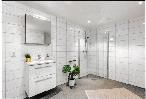 Baderomsinnredning med ny moderne skuffeinnredning med nedfelt servant og praktisk speilskap over servant med toppmontert belysning. Varme i flislagt gulv. Galleribilde