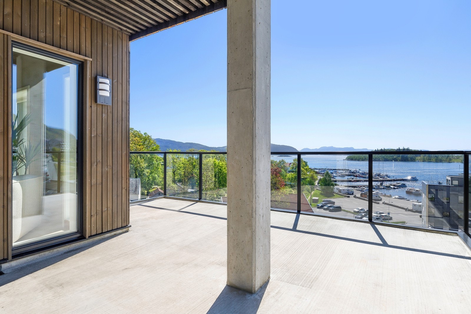 Romslig balkong med flott utsikt mot båthavna, fjorden og øyene Galleribilde