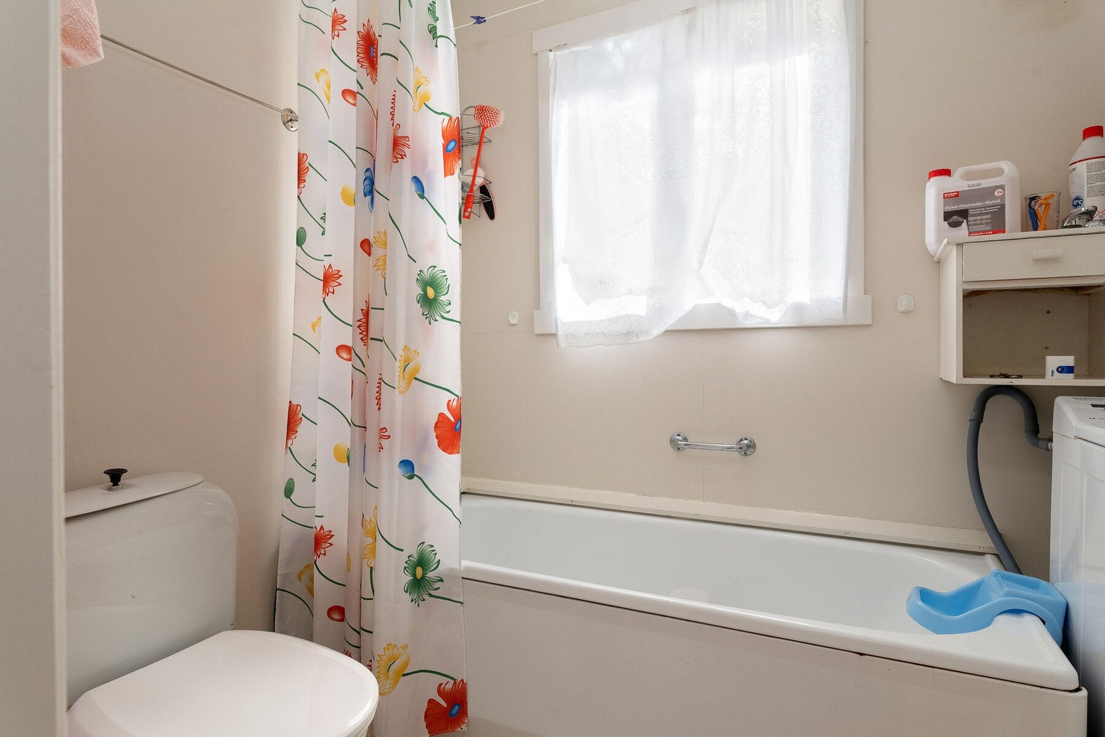 Bad i 1. etasje med toalett, servant, badekar og dusj på vegg Galleribilde