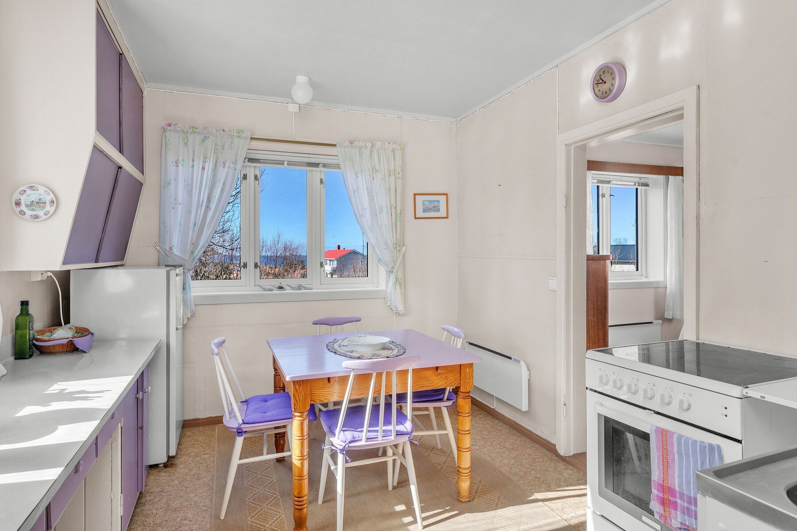 Eldre innredning bestående av kjøkkenbenk med heldekkende stålbeslag med kummer, benkeplate, takhøy overskap og underskap med glatte fronter Galleribilde