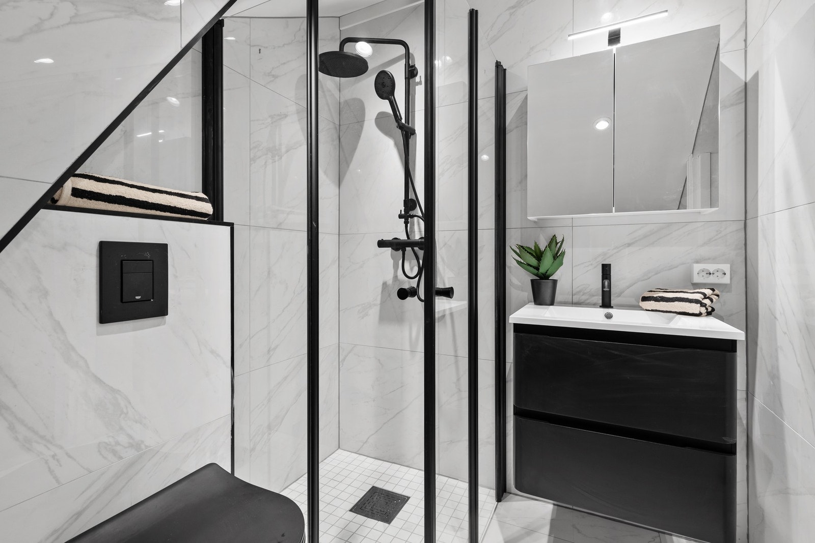 Rommet er utstyrt med dusjnisje, baderomsinnredning med servant og speil, samt vegghengt toalett med innebygget sisterne Galleribilde