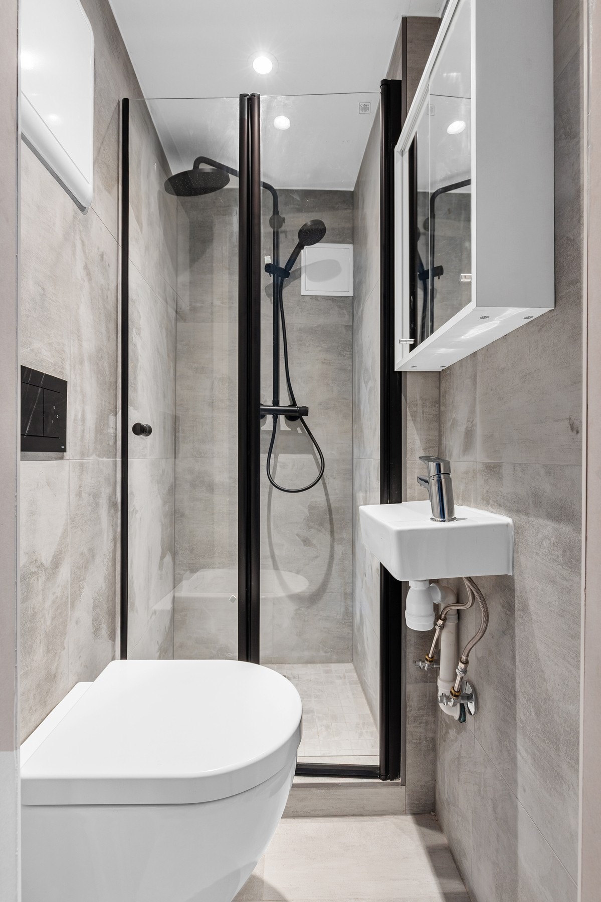 Helfliset bad fra 2025 med dusjnisje, vegghengt toalett, servant og speilskap Galleribilde