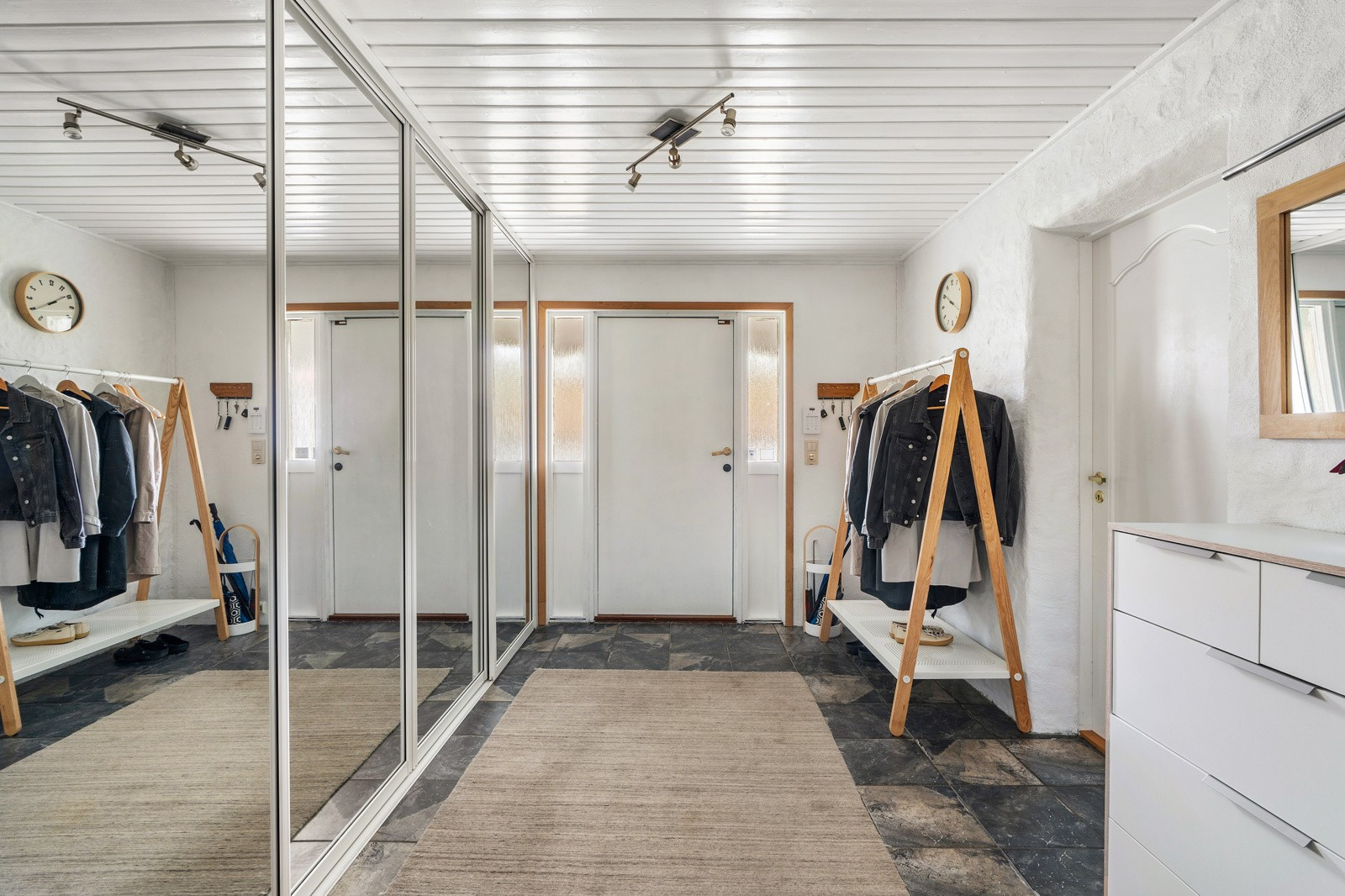 Velkommen inn! Her ønskes du velkommen inn til en flott flislagt entré med romslig integrert garderobeskap.