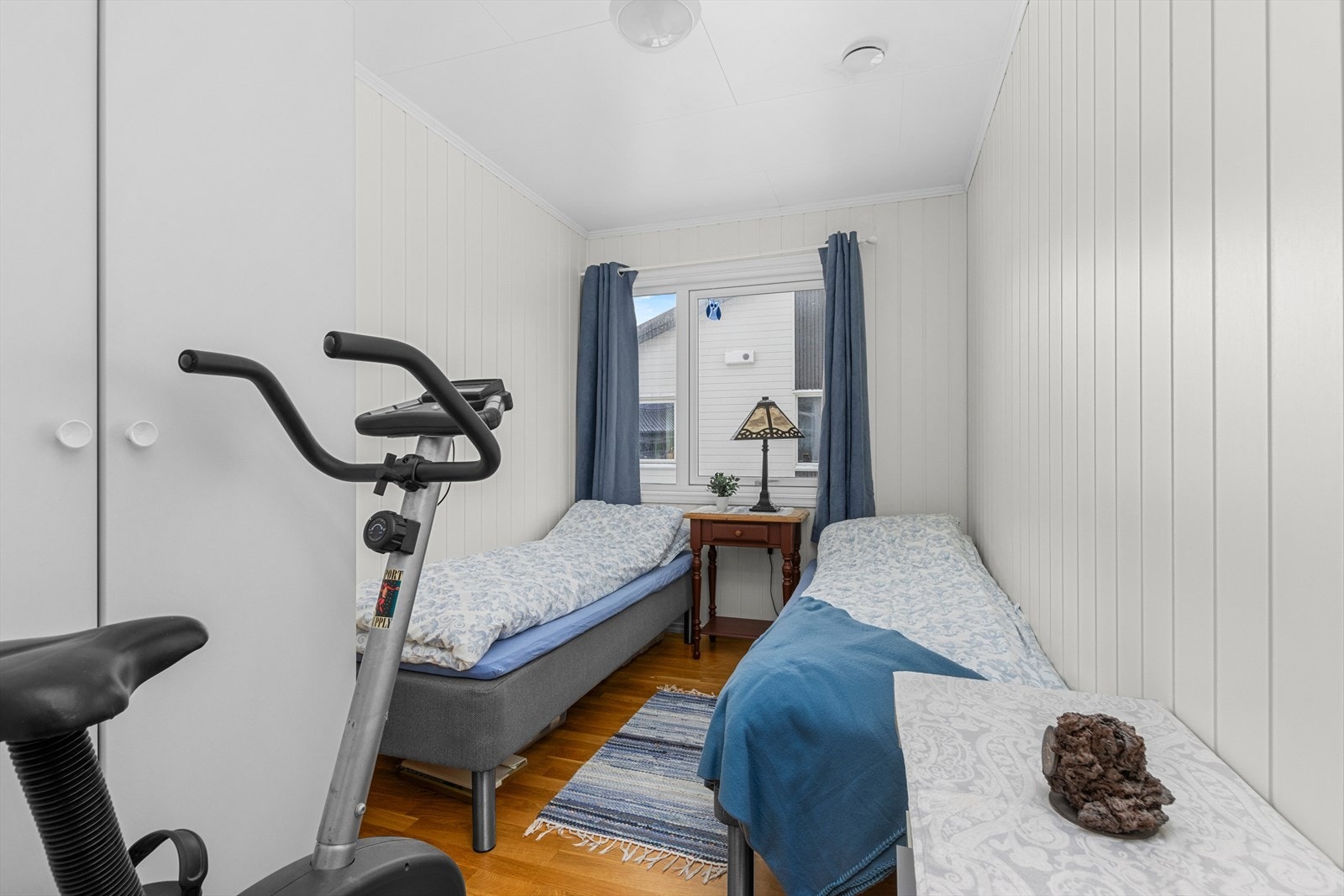 Det ene soverommet er innredet med et hvitt garderobeskap. Galleribilde