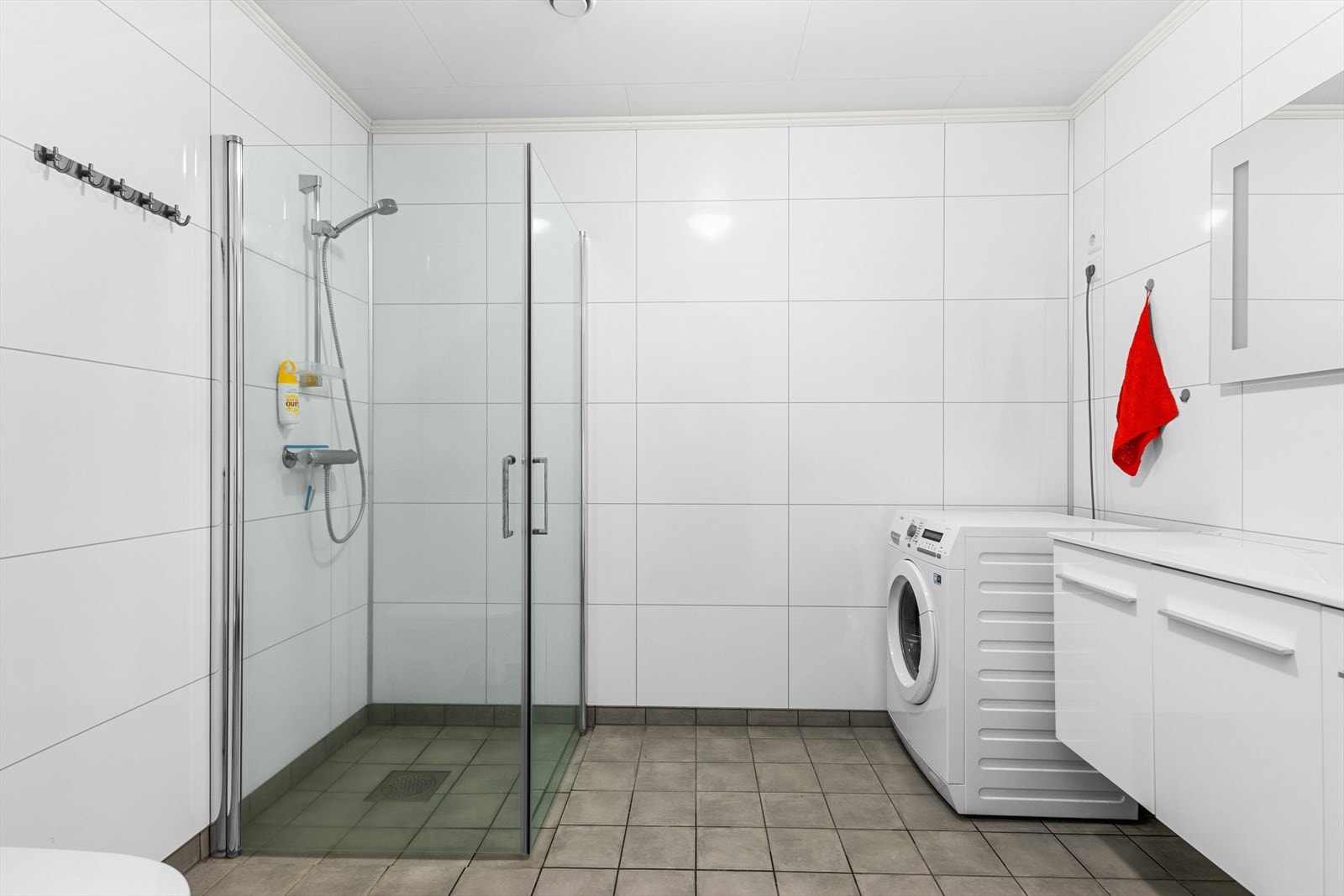 Dagene får en god start på et romslig bad med flislagt gulv, vegghengt toalett og opplegg for vaskemaskin. Galleribilde