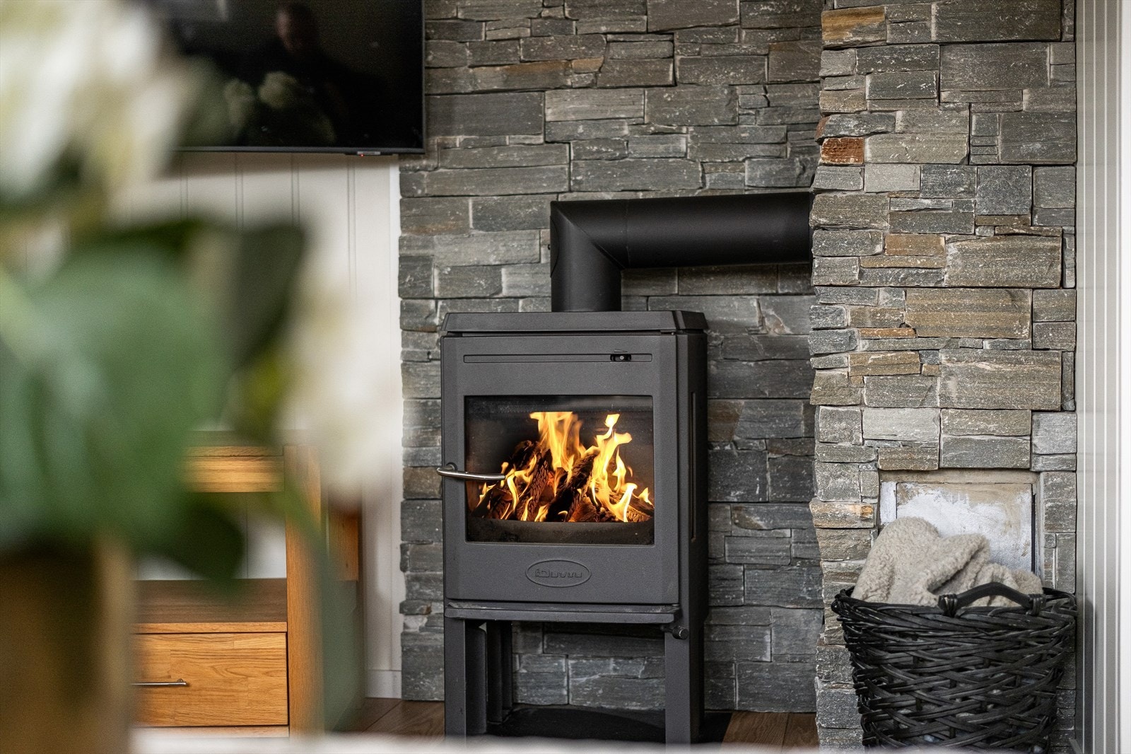 Det er etablert vedovn for ekstra kos og varme i vinterhalvåret med flott skifervegg Galleribilde