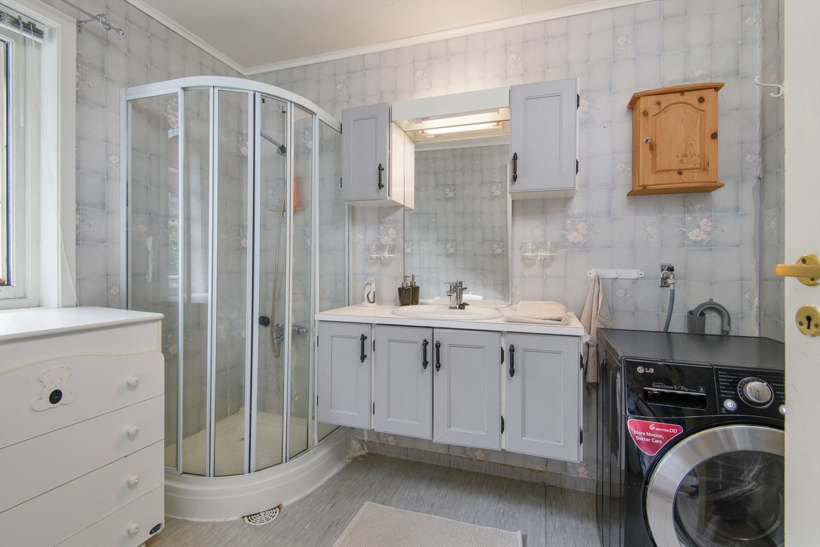 Baderommet på hovedplan har baderomsinnredning med servant, dusjkabinett og opplegg for vaskemaskin Galleribilde