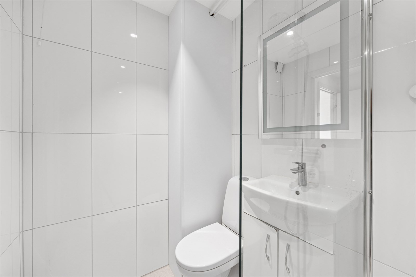 Badet er innredet med nedfelt servant, toalett og dusjhjørne. Galleribilde