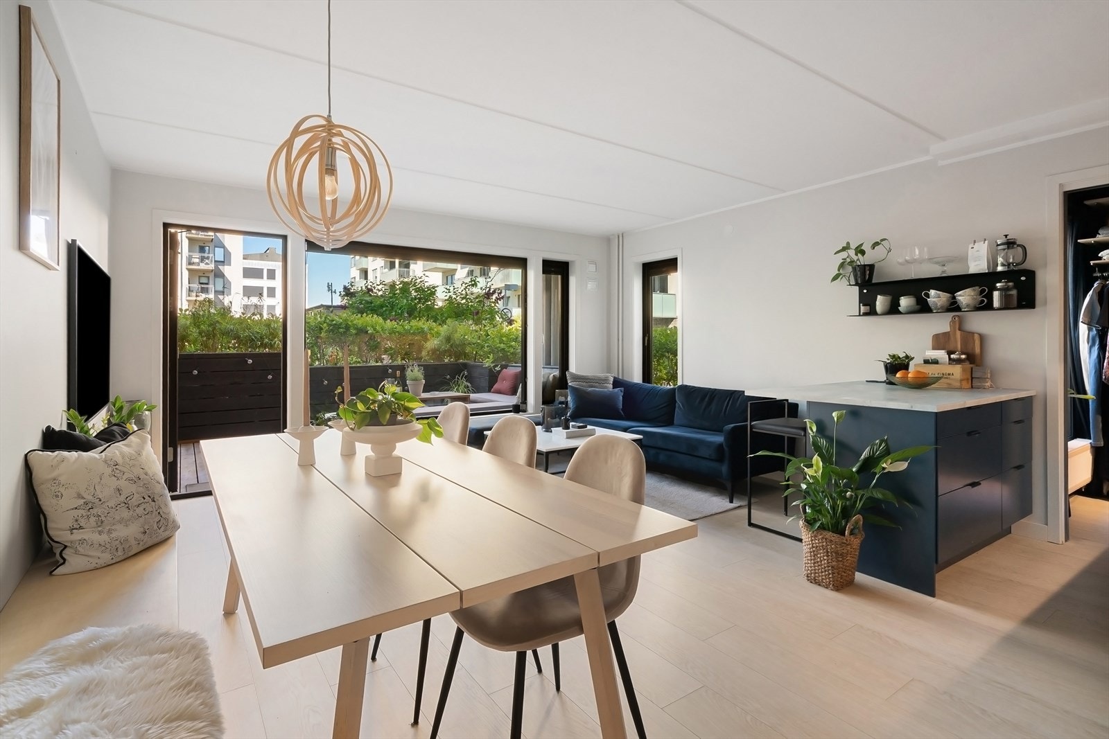 Stue og kjøkken i åpen løsning som gir flere møbleringssoner Galleribilde