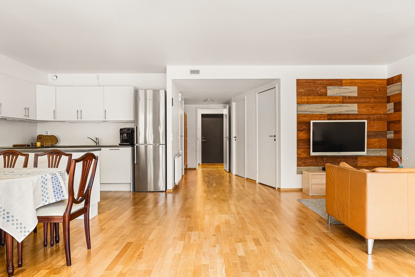 Fra gangen ledes man inn i boligens åpne stue- og kjøkkenløsning. Galleribilde