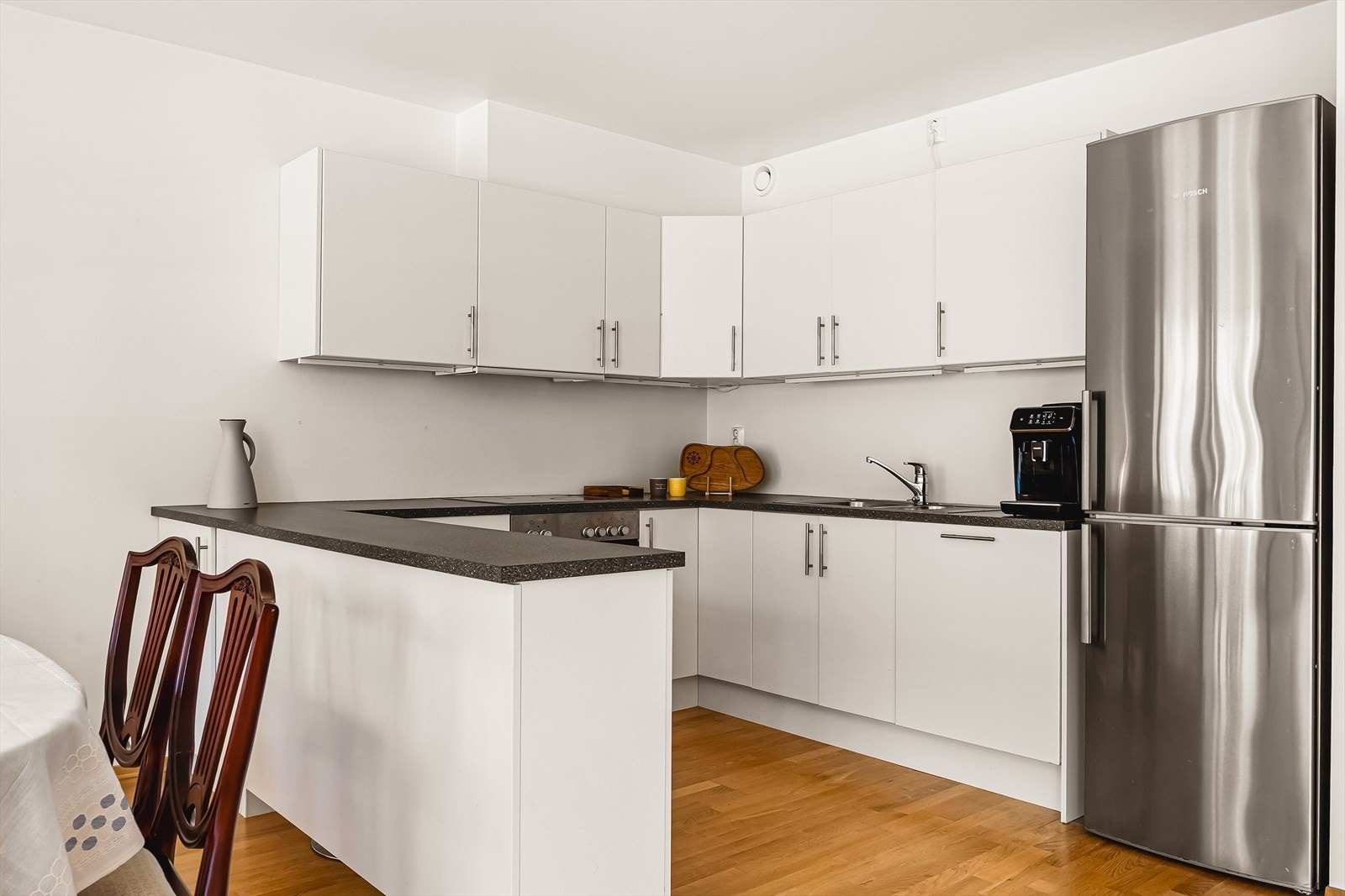 Kjøkkenet er funksjonelt utformet med rikelig skap- og benkeplass, samt en praktisk og sosial kjøkkenøy som både gir ekstra arbeidsflate. Galleribilde