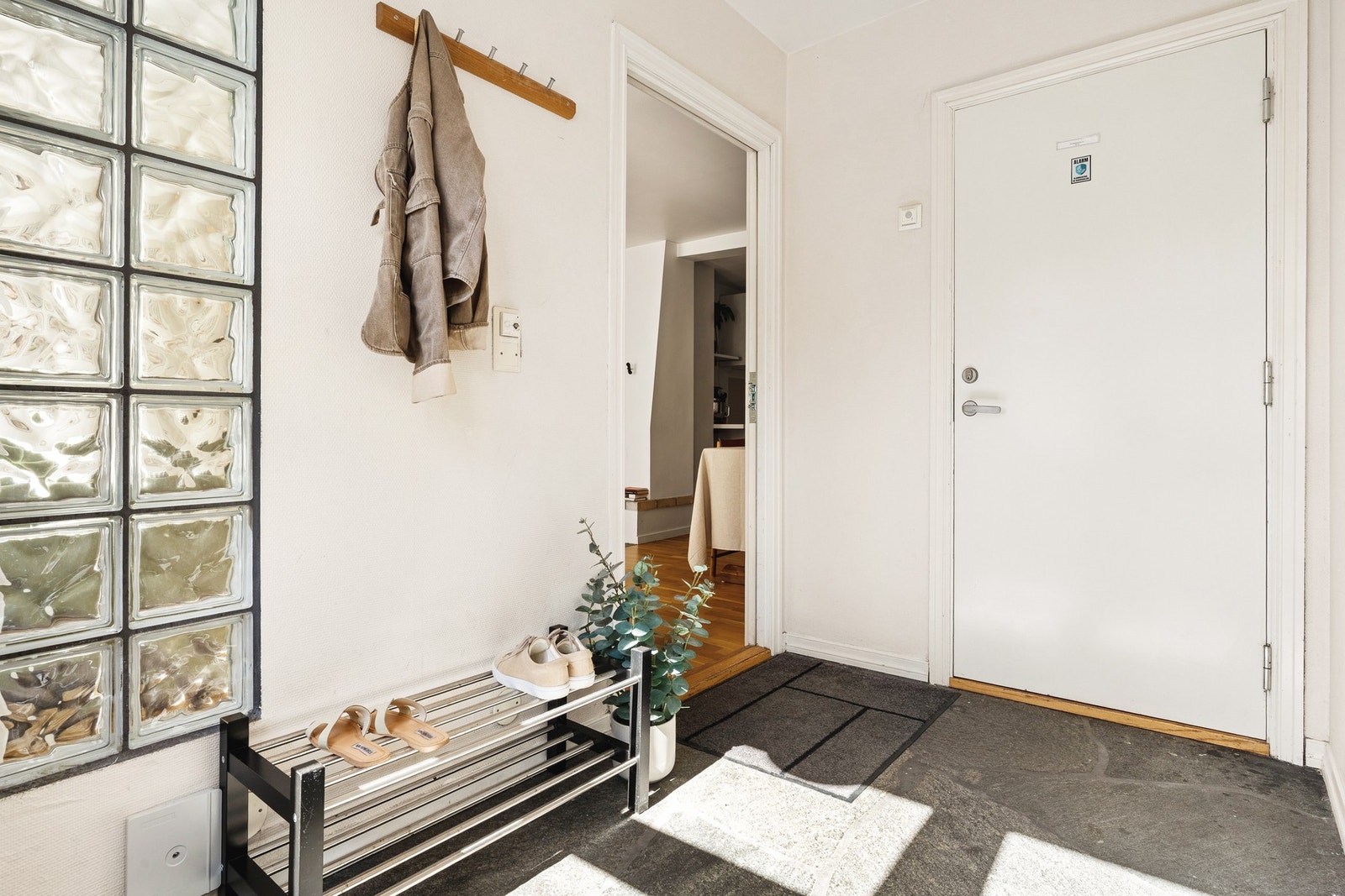 Her er det plass til å henge fra seg yttertøy og sko, og overflatene er holdt i samme harmoniske stil som resten av boligen. Galleribilde