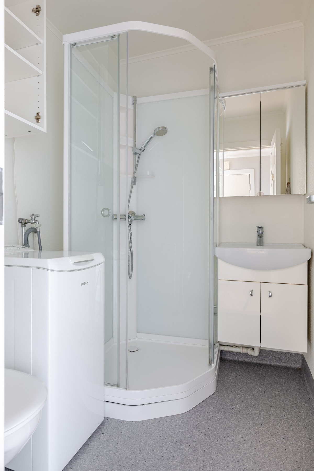Badet har innredning med nedfelt servant, toalett, dusjkabinett
og opplegg for vaskemaskin. Galleribilde