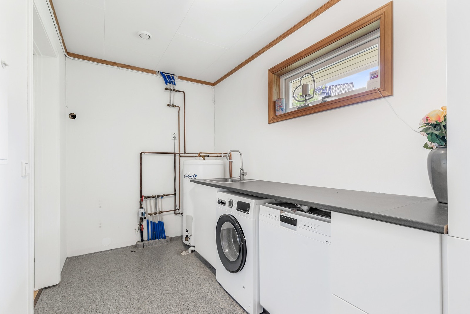 Separat vaskerom med belegg på gulv med gulvvarme, malte flater på vegger og takplater i himling Galleribilde