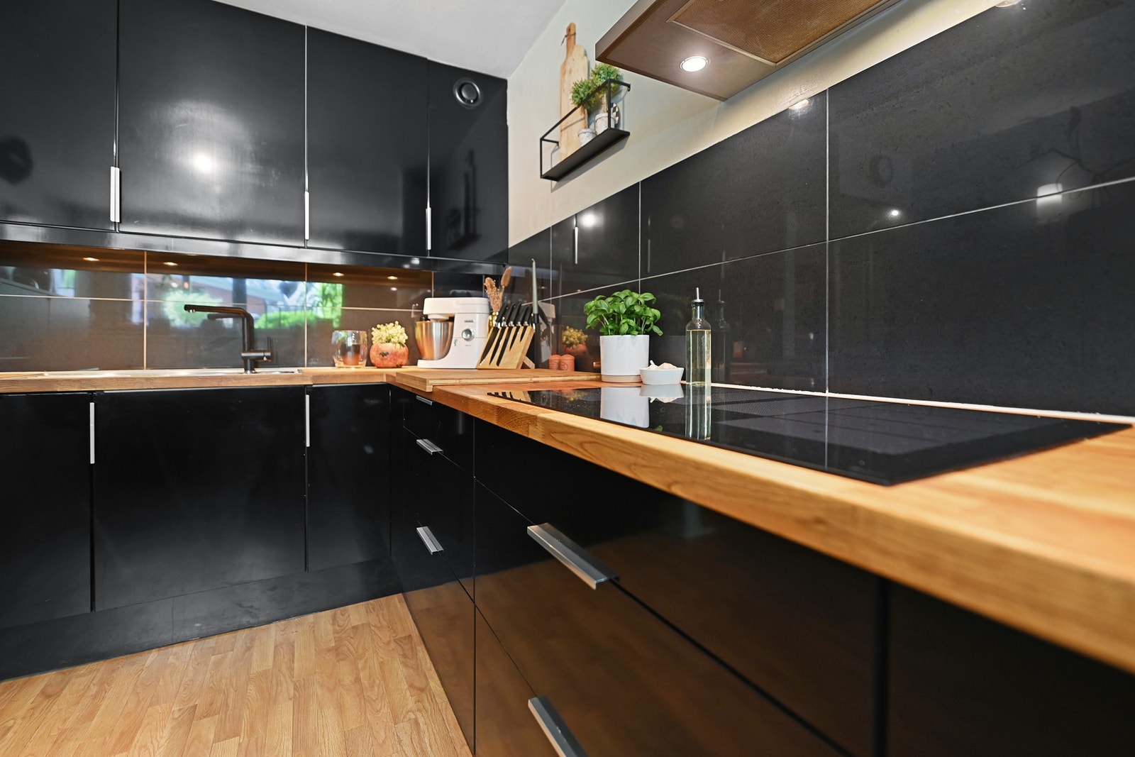 Integrerte hvitevarer som komfyr, oppvaskmaskin, mikroovn, induksjonstopp og kjøleskap. Blandebatteri og induksjonstoppen er fra 2025 og komfyren er fra 2023. Det er flotte fliser over benkeplaten. Galleribilde