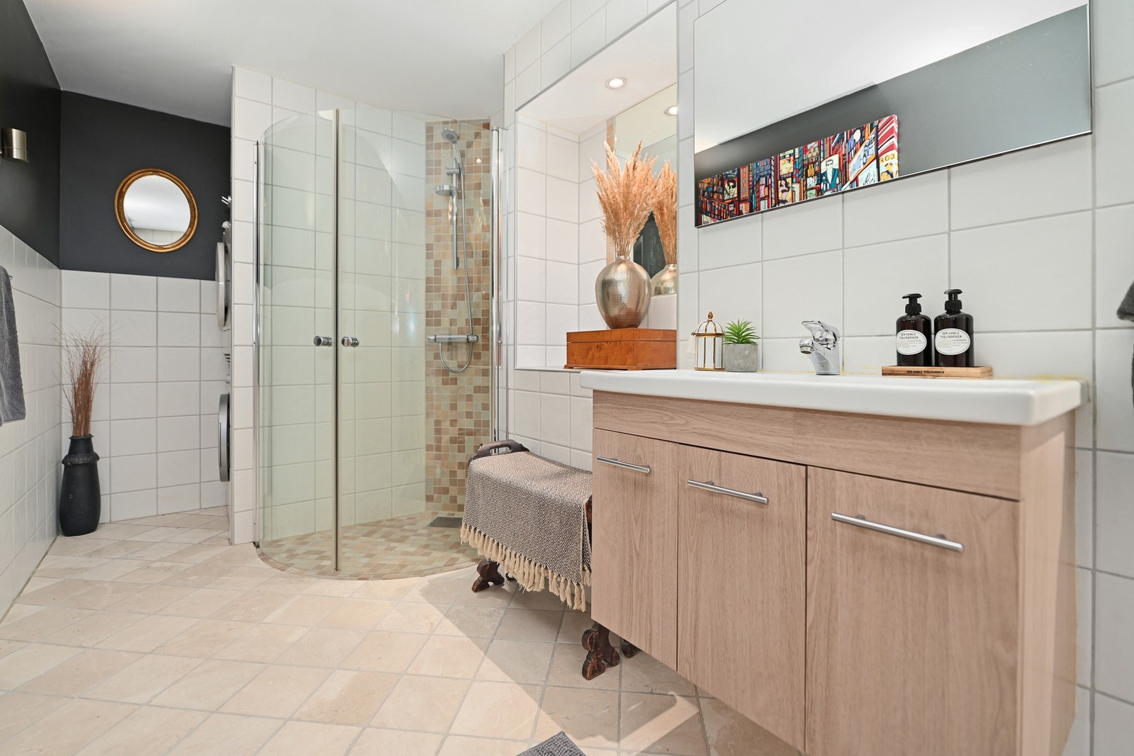 Badet er innredet med vegghengt wc, servantskap, speil, veggskap, dusjhjørne og opplegg for vaskemaskin. Galleribilde