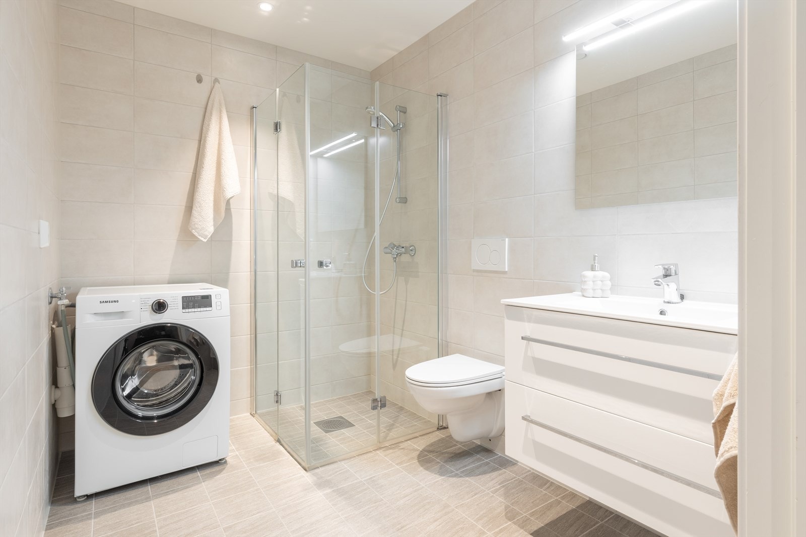 Badet er lekkert helfliset med lyse fliser på vegg - og gulvflater. Galleribilde
