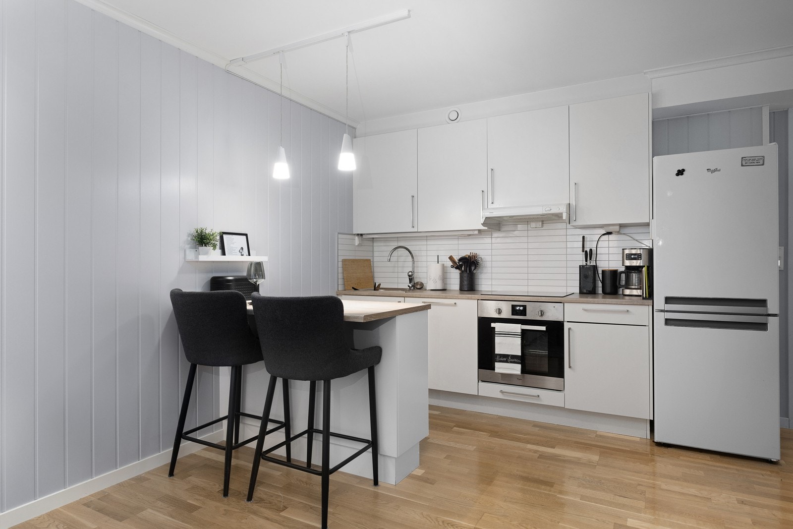 Kjøkkeninnredning fra Sigdal med glatte fronter, laminat benkeplate og kitchenboard på vegg over benkeplate. Galleribilde
