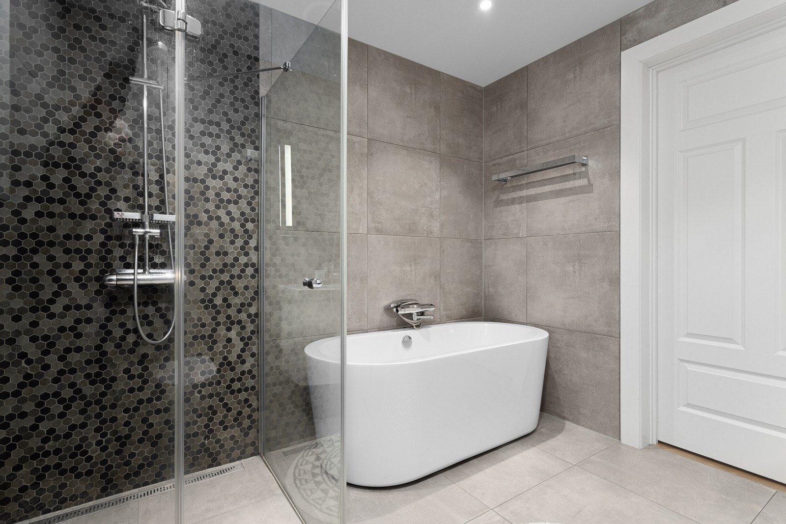 Badet i 1. etasje har innredning i høyglans og porselen vask, samt vegghengt toalett, badekar og dusjhjørne med glassdør. Galleribilde