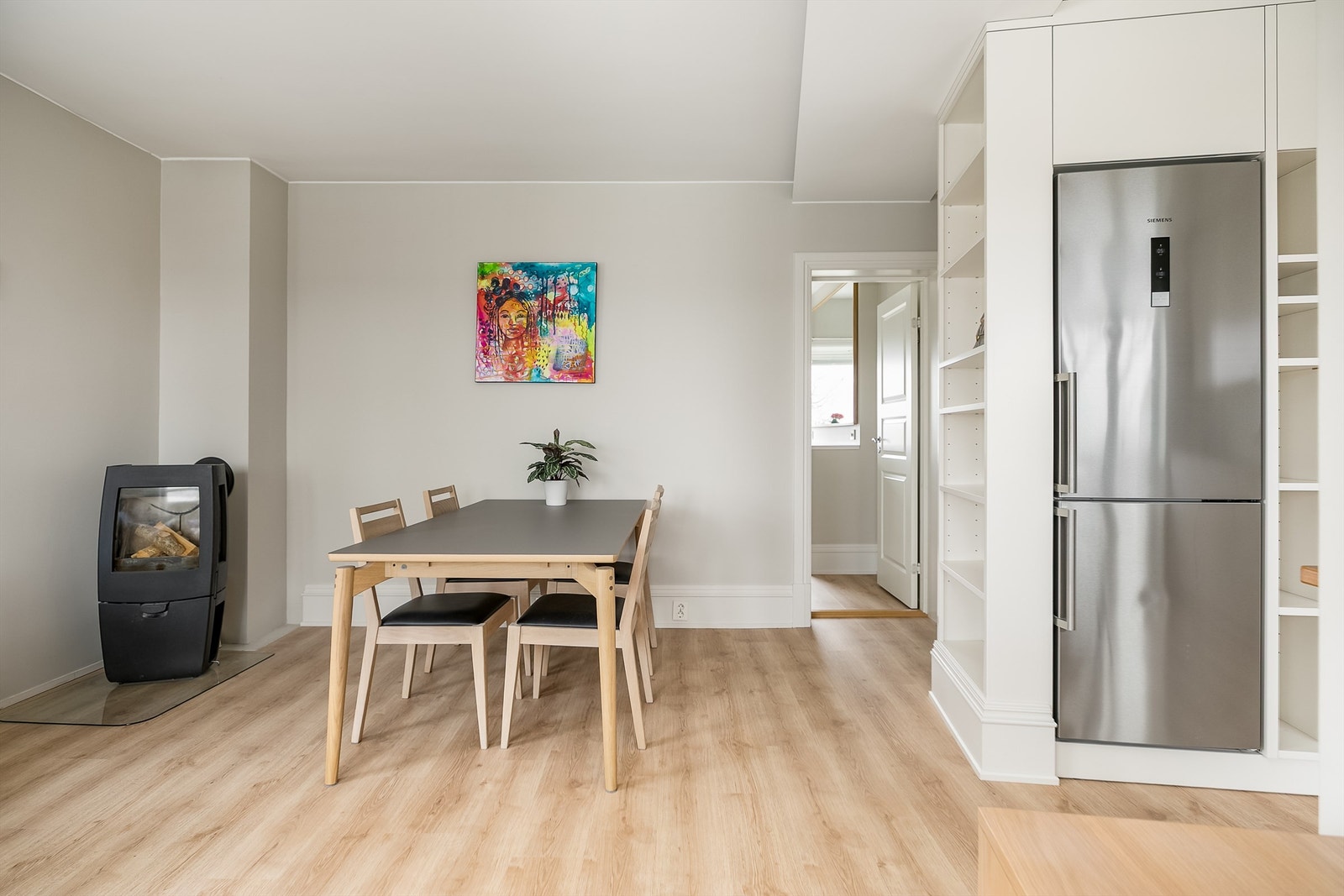 Gjennomgående parkett og plassbygget innredning gir sømløs overgang mellom stue og kjøkken. Galleribilde