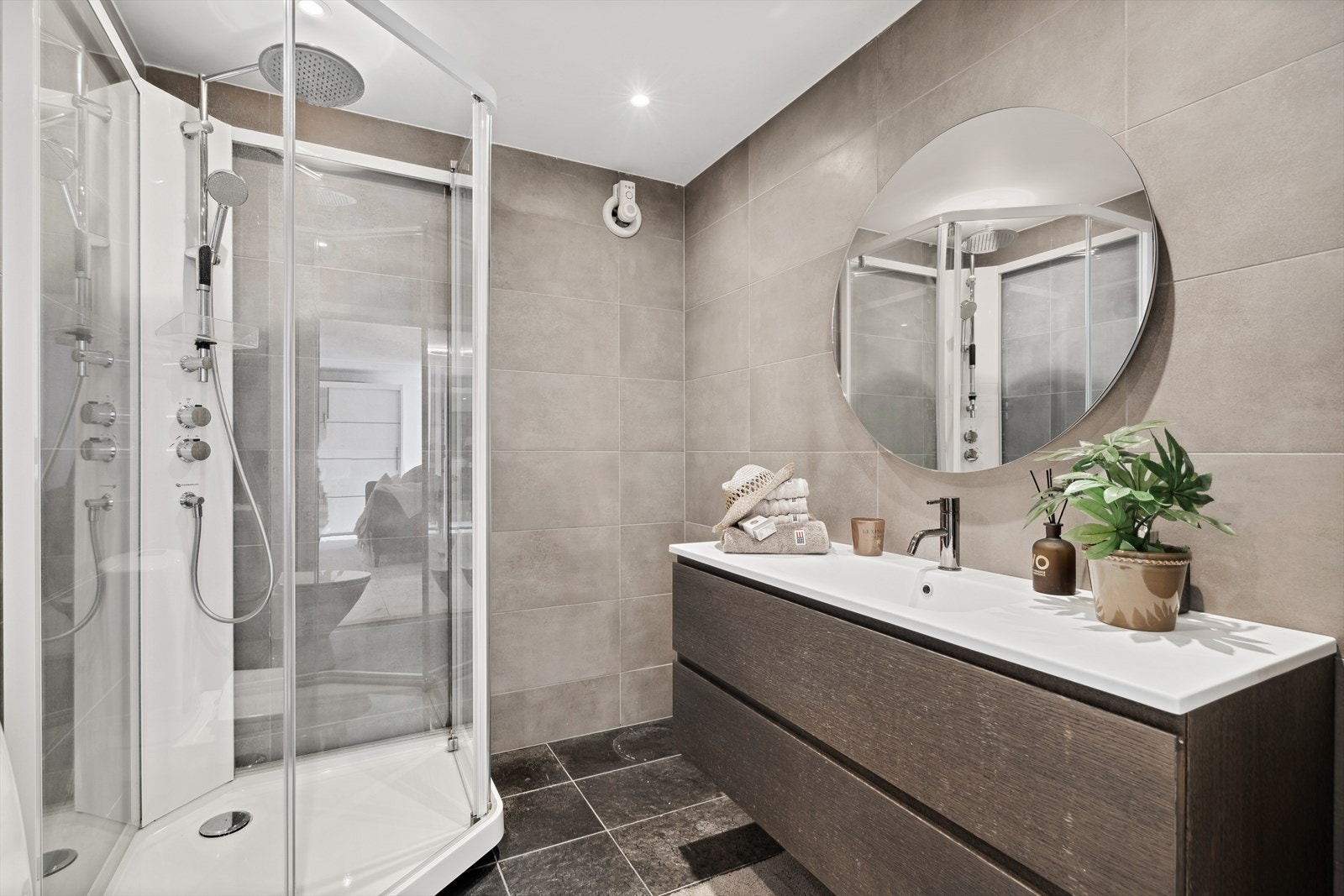 Baderom utstyrt med servant nedfelt i innredning samt dusjkabinett. Varmekabler i gulv. Galleribilde