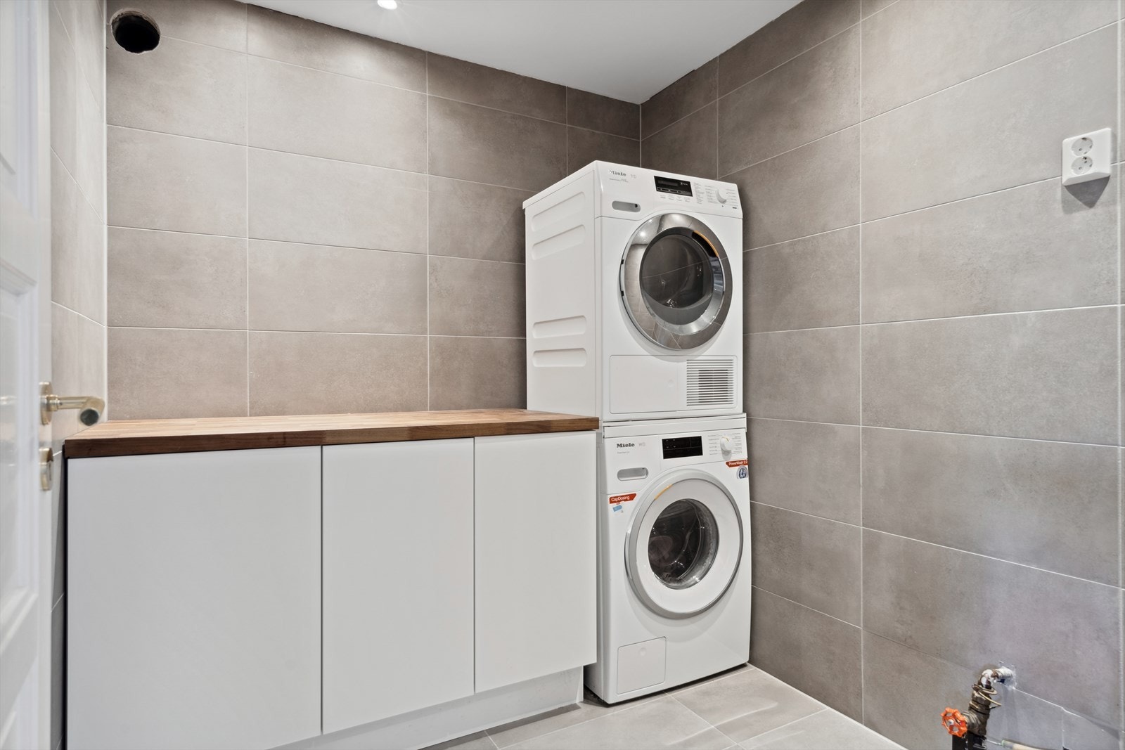 Separat vaskerom med opplegg for vaskemaskin og tørketrommel. Skap- og benkeplass. Galleribilde