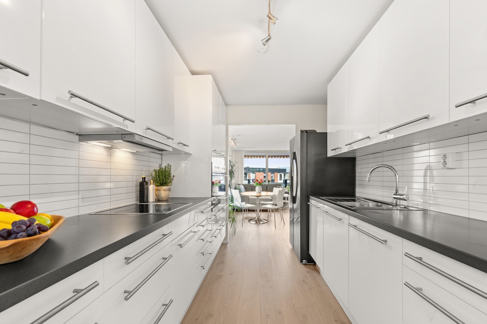 Lys kjøkkeninnredning med glatte fronter i høyglans. Galleribilde