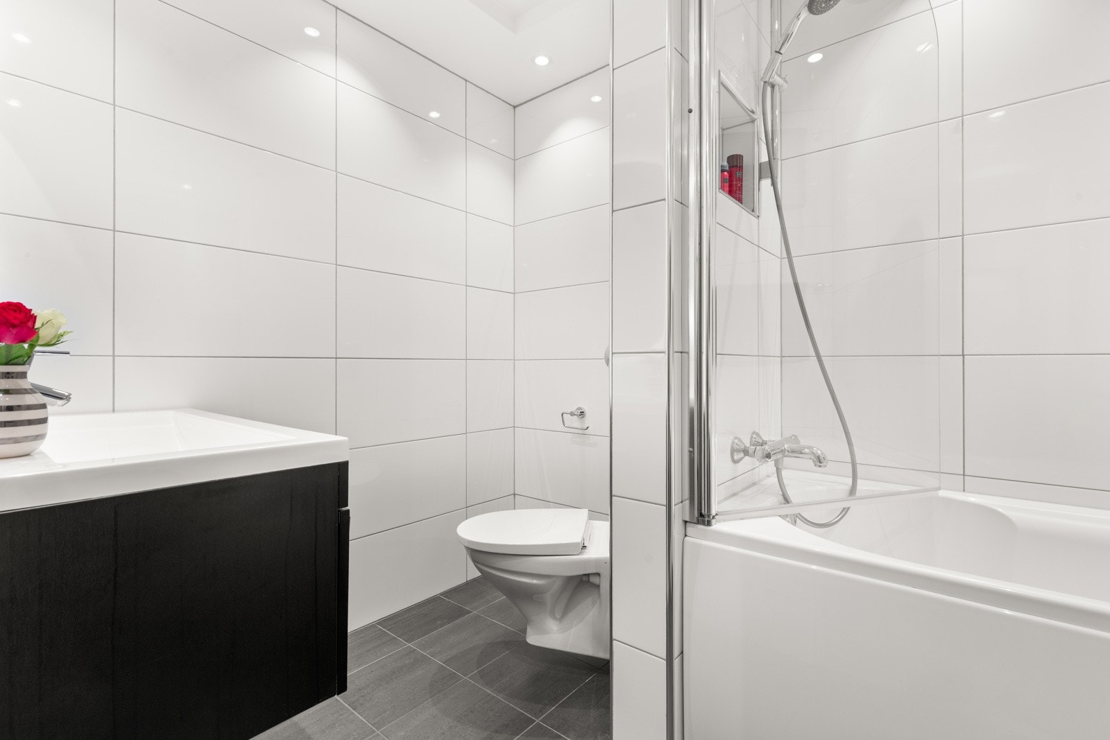 Lyst og pent flislagt baderom fra 2008 med flislagte vegger, slett himling og med flislagt gulv med behagelig varme. Galleribilde