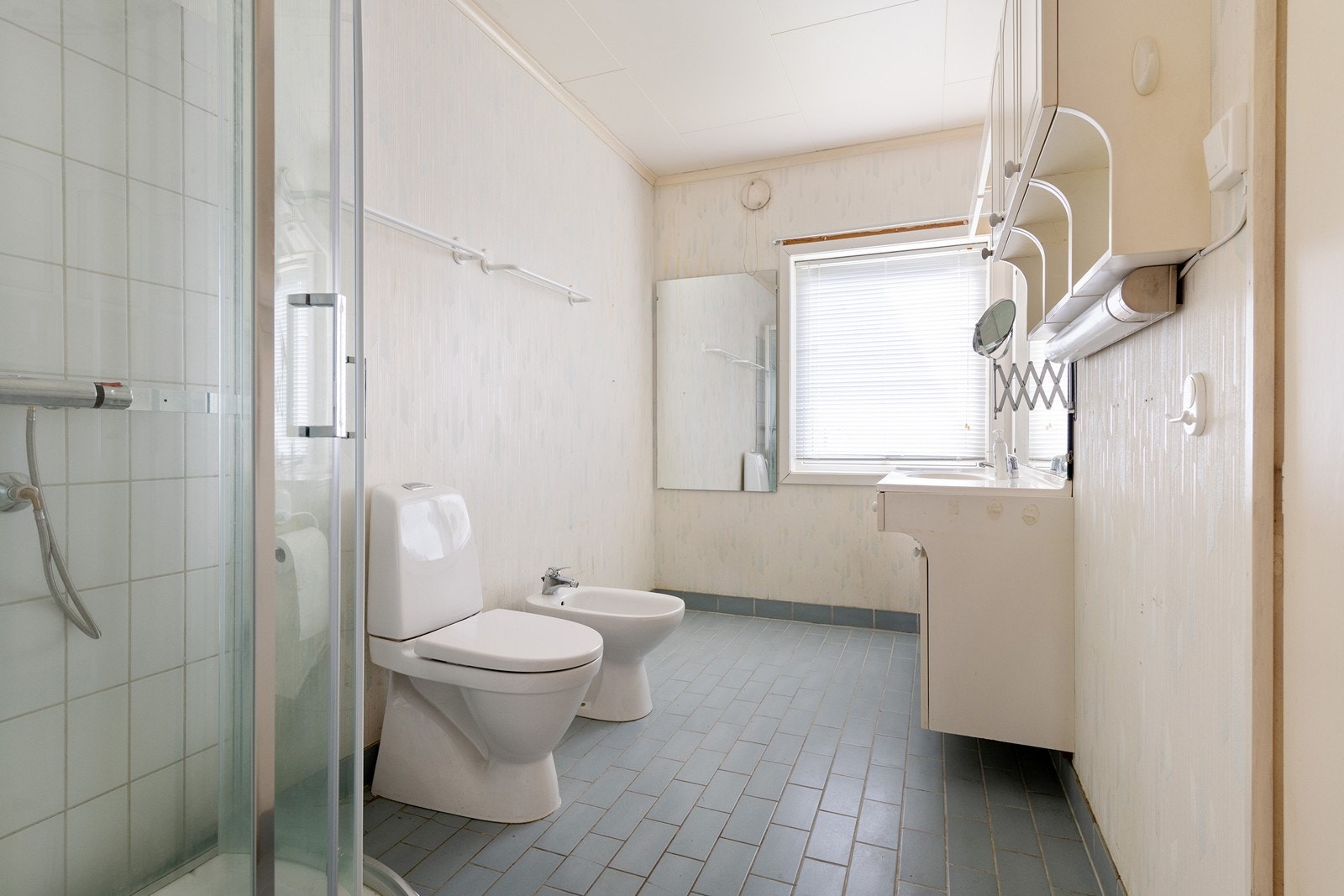 Bad med dusjkabinett, toalett og enkel servant. Galleribilde