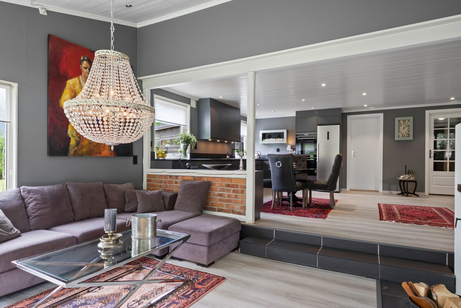 Stuen har flislagt trapp mellom nivåene, downlights i himlingen, gråmalte, glatte veggflater, enstavs laminatgulv og god plass til en romslig tv-lounge. Galleribilde