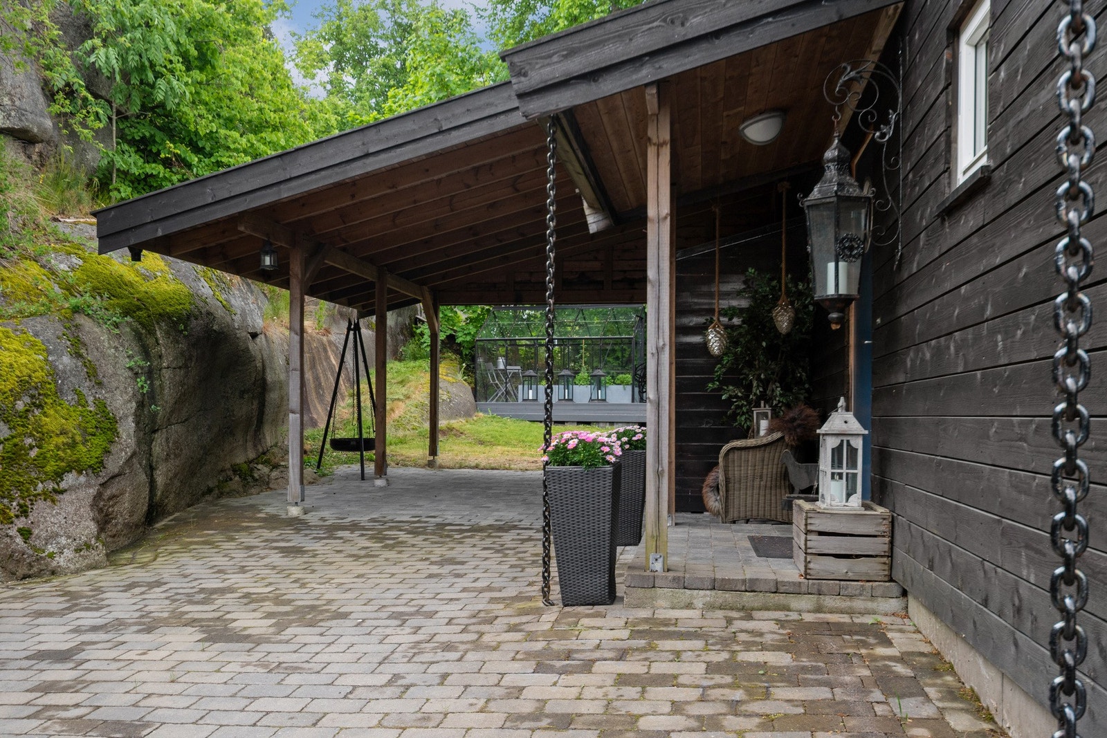 Foran boligen og i carporten er det lagt belegningsstein og bygd et overbygg over ytterdøren. Galleribilde