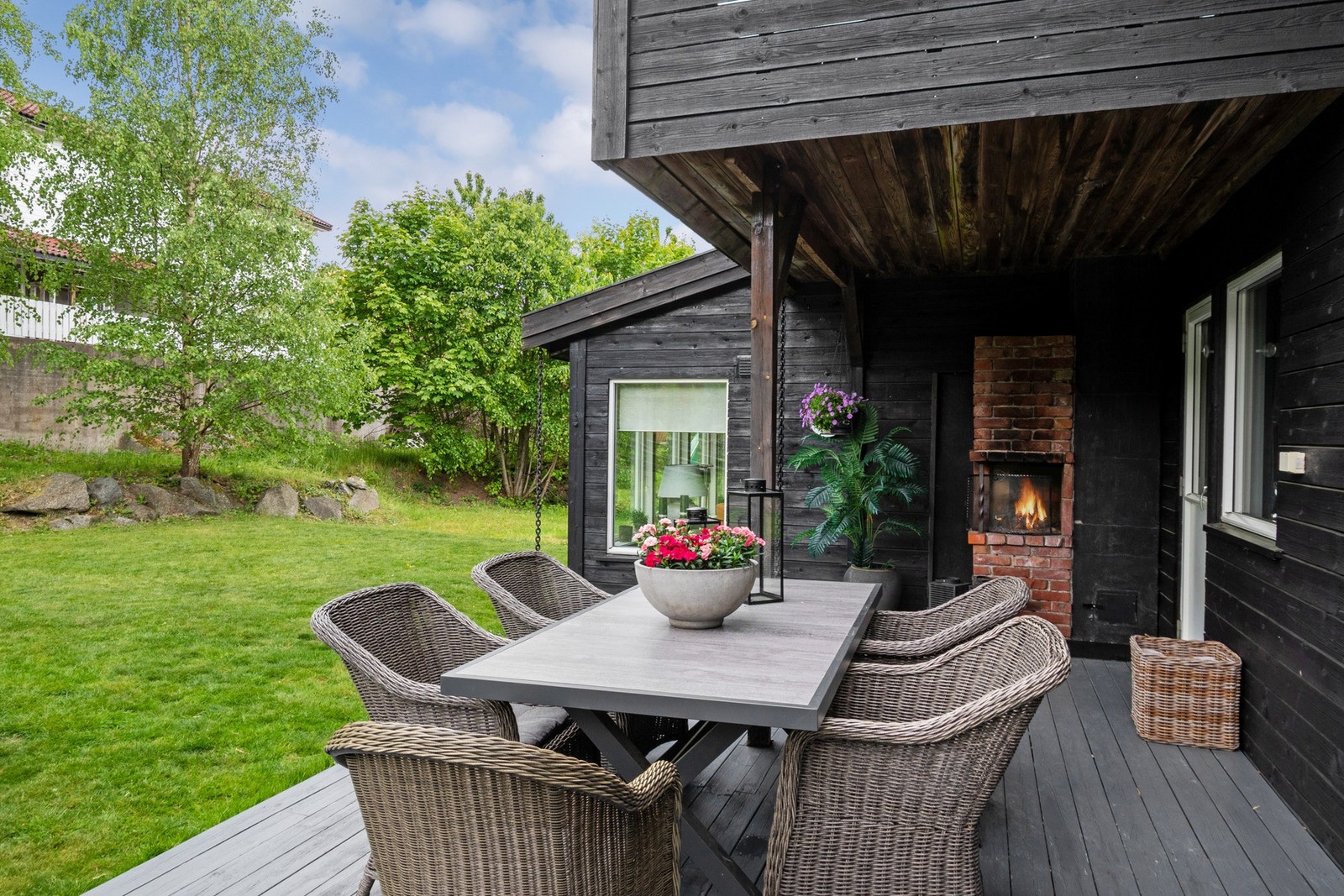 Den ene delen av terrassen har en lun utepeis i teglstein. Galleribilde