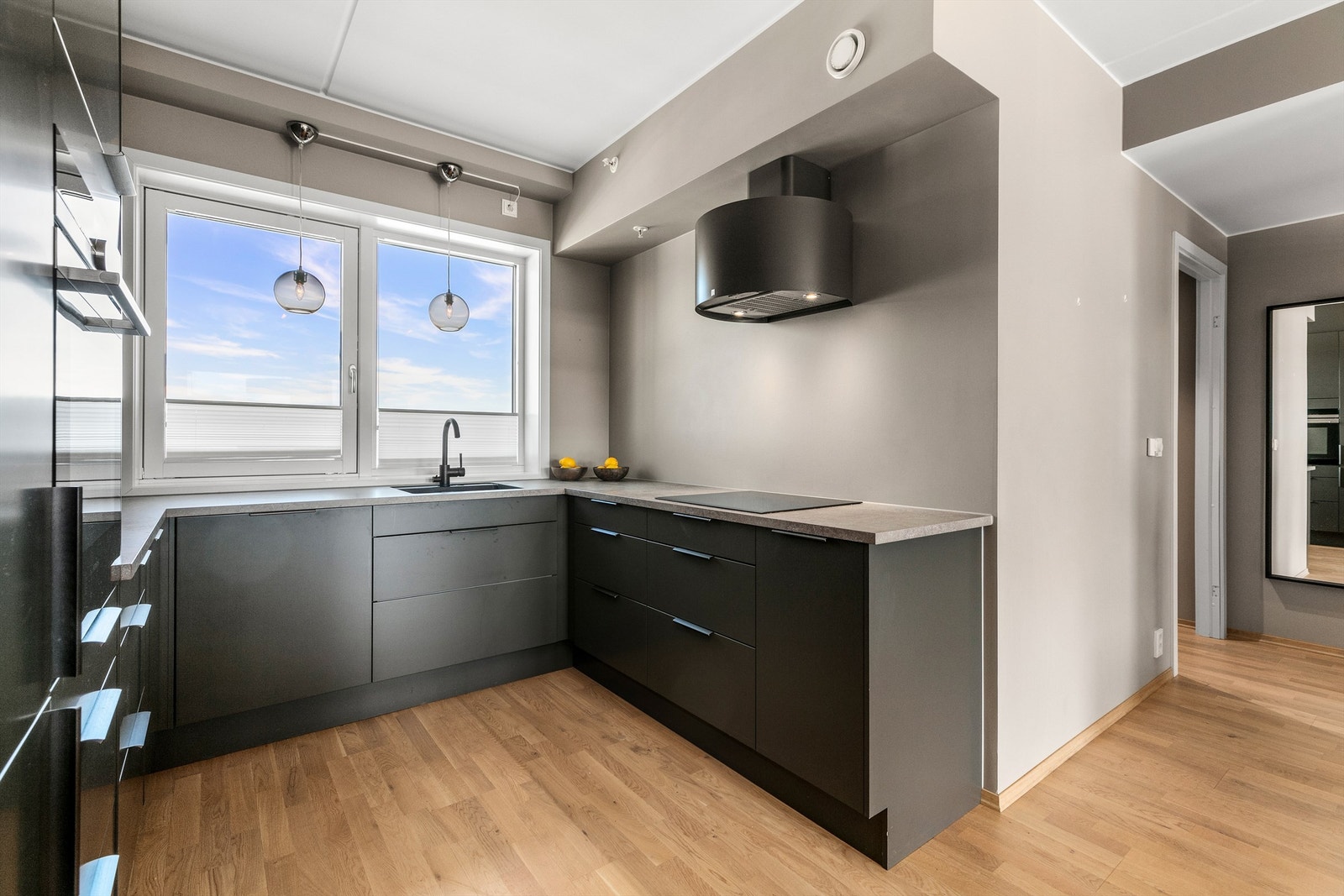 Kjøkkenet har fine arbeidsflater og vinduer gir supert naturlig lys inn på kjøkkenet. Stilig avtrekkshette fra Røroshetta over platetoppen. Galleribilde