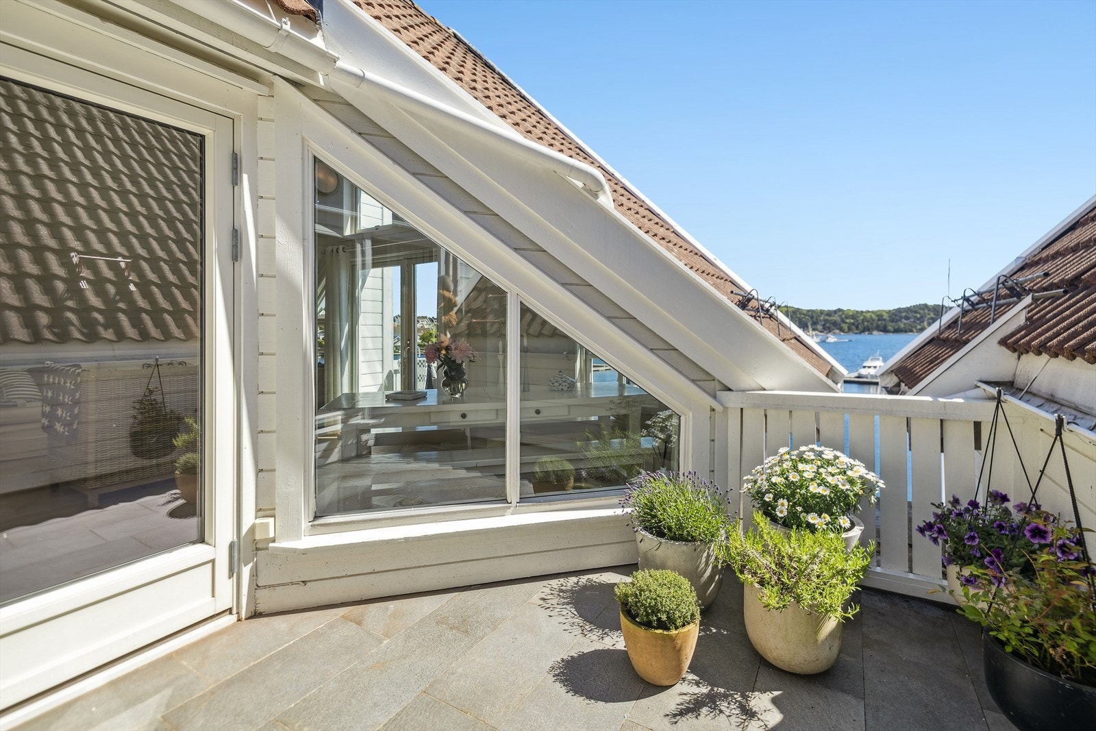 Usjenert terrasse med sen ettermiddags sol. Det er denne terrassen, med vindusløsningene mot stuen, som er med på å skape særpreget. Galleribilde